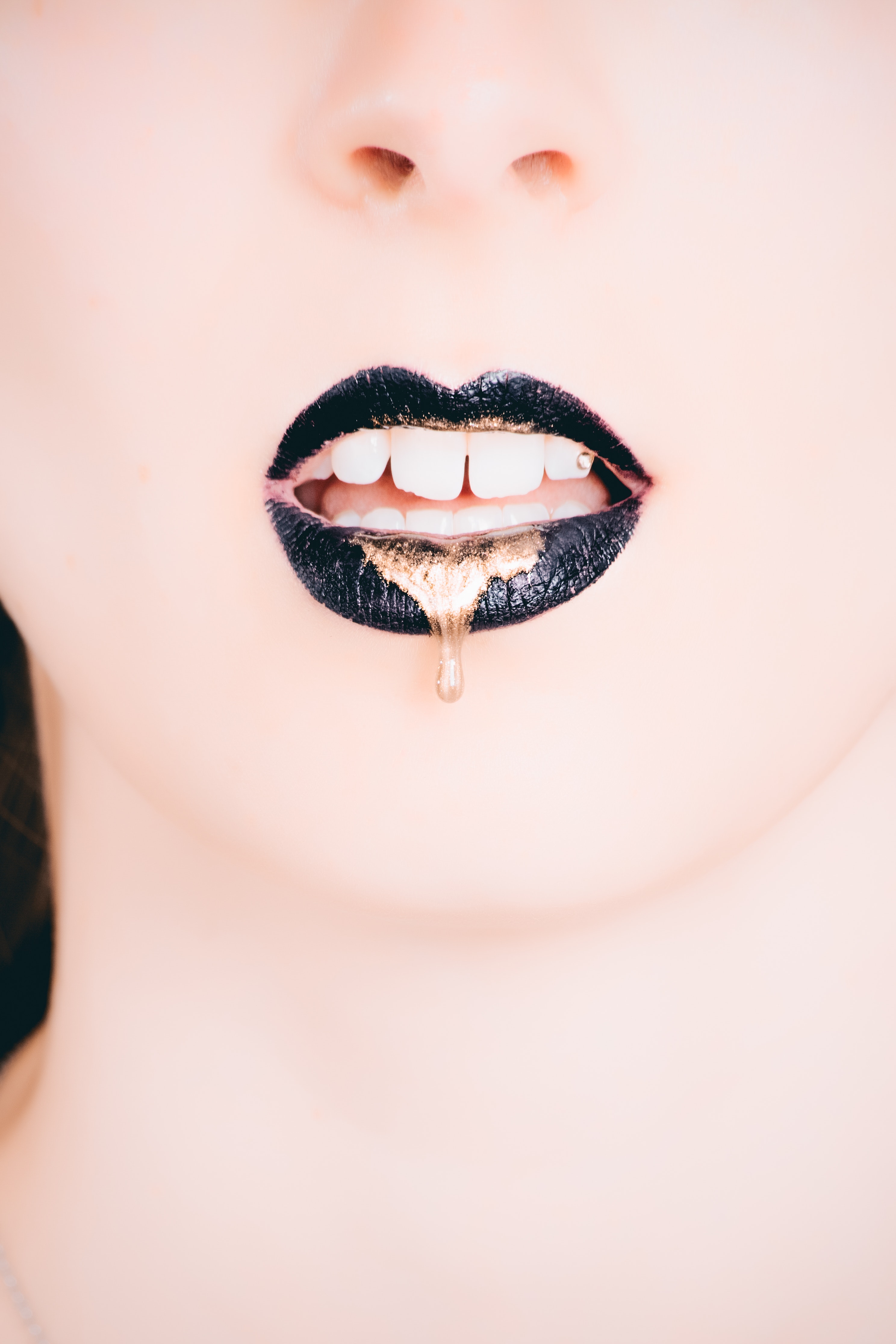 Woman wearing black lipstick with gold dripping out photo