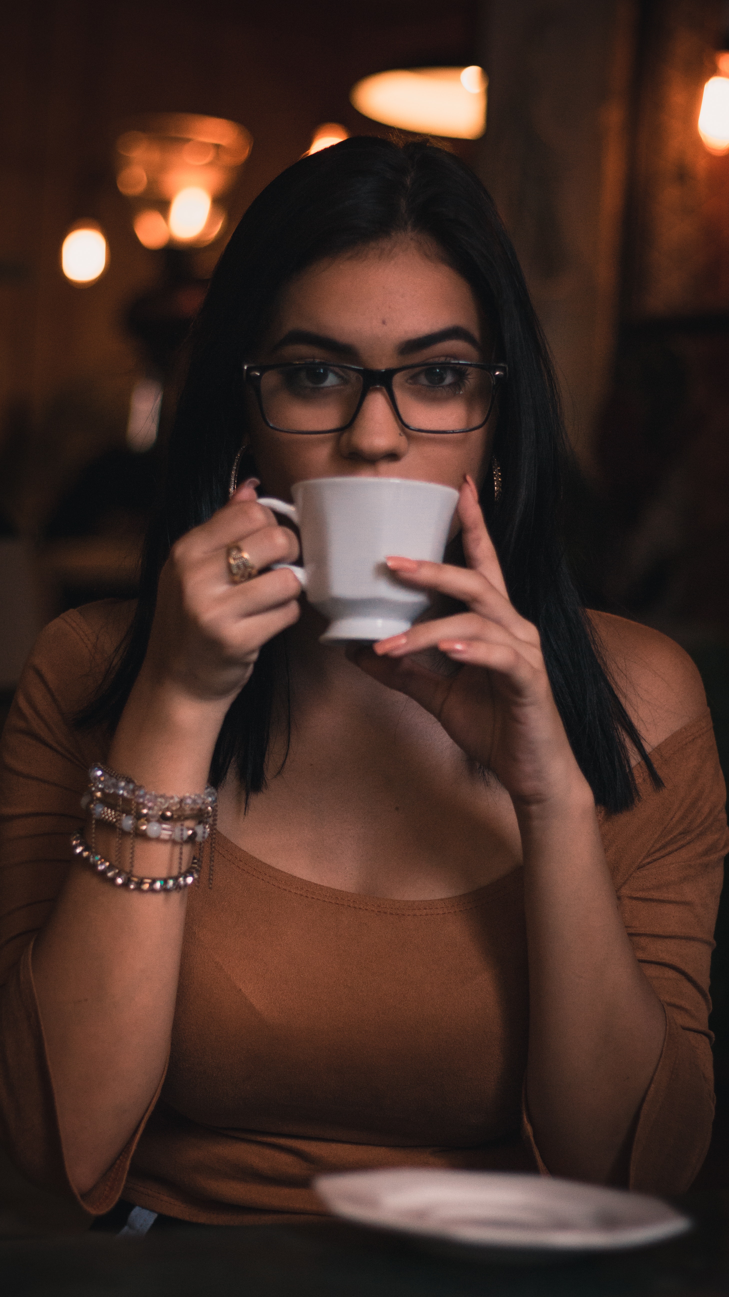 Woman wearing brown scoop-neck quarter-sleeved top holding white ceramic mug photo