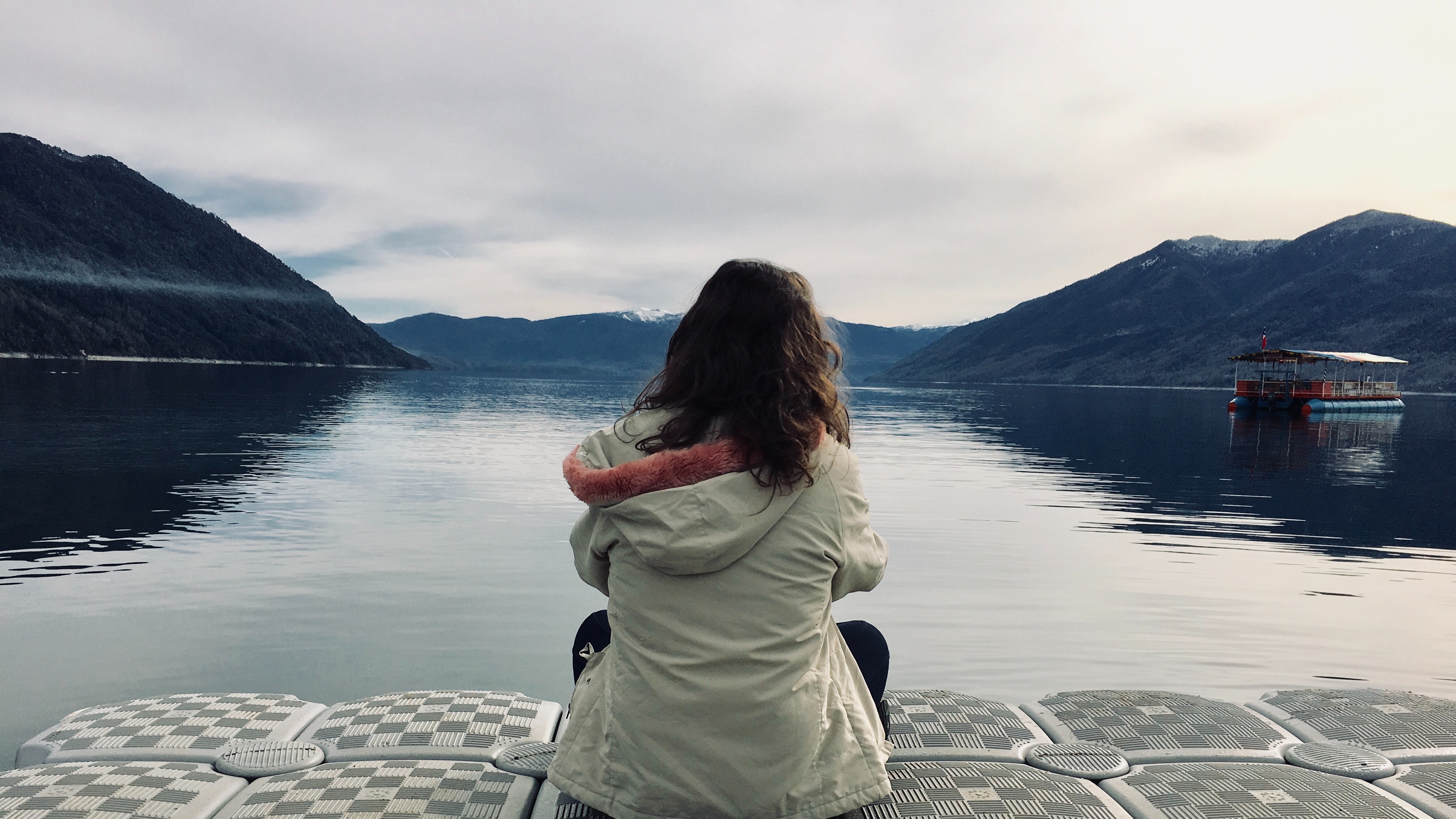 Woman wearing gray jacket in front of body of water photo