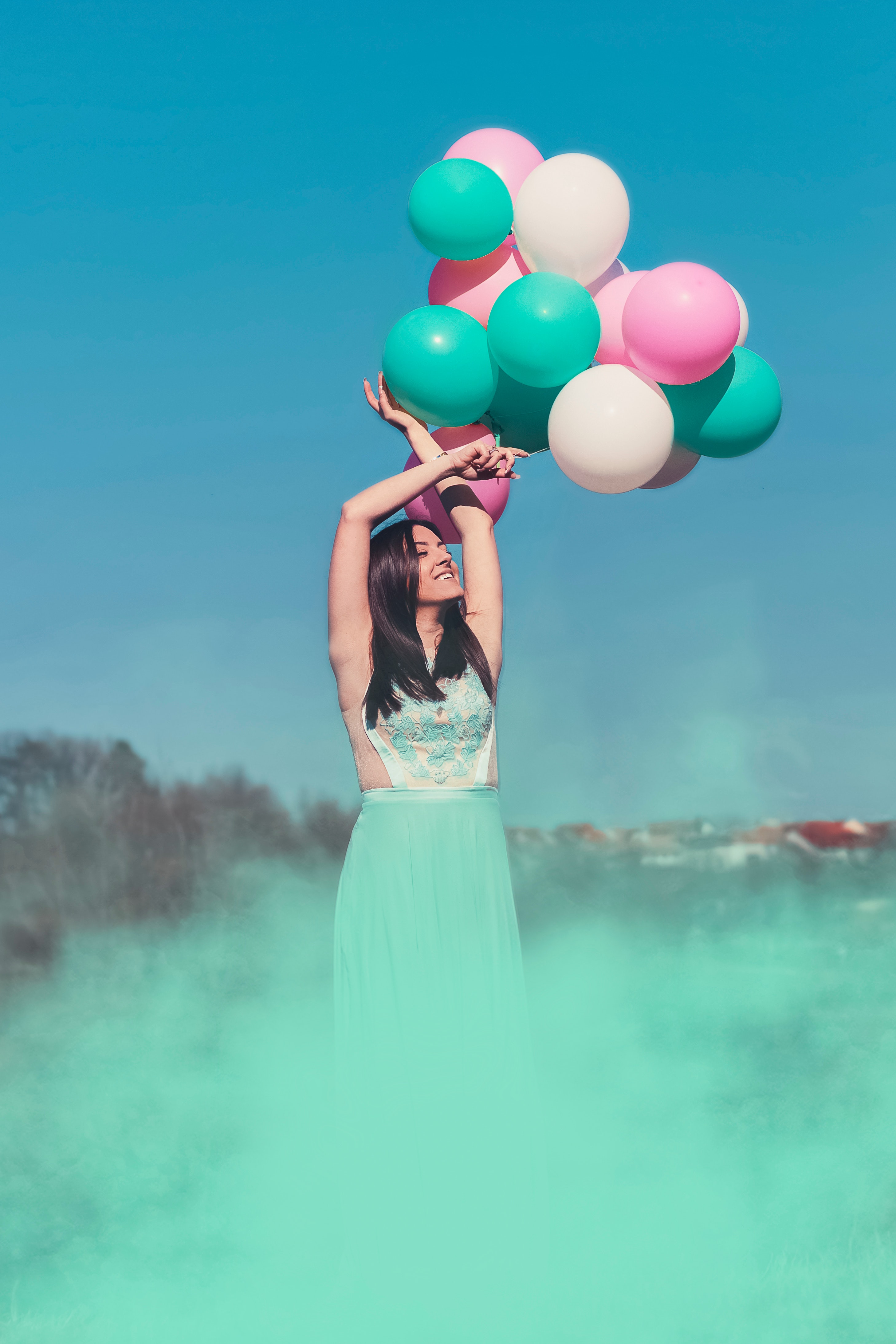 Woman wearing green dress holding balloons photo