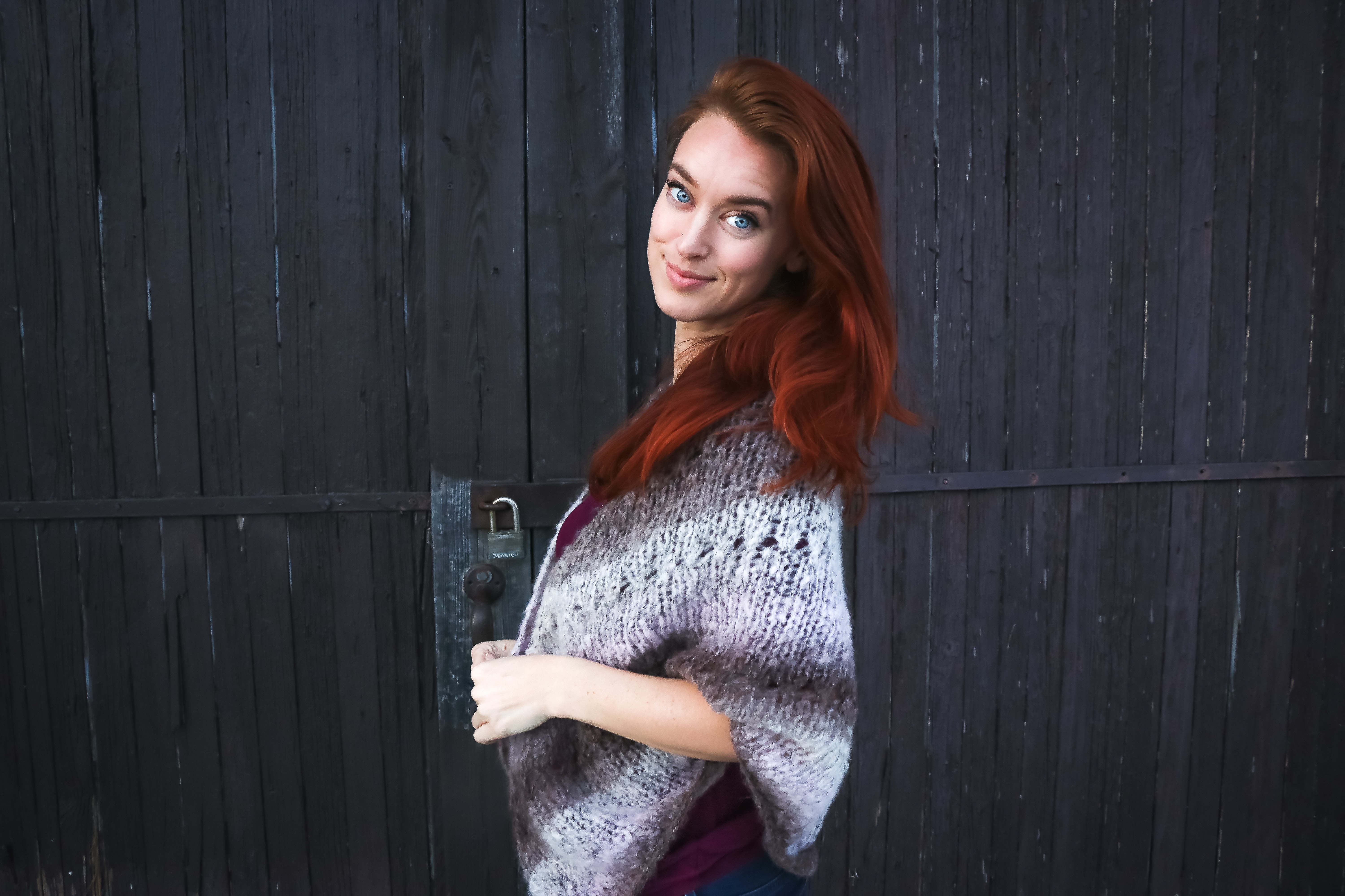 Woman wearing grey printed poncho posing for photo