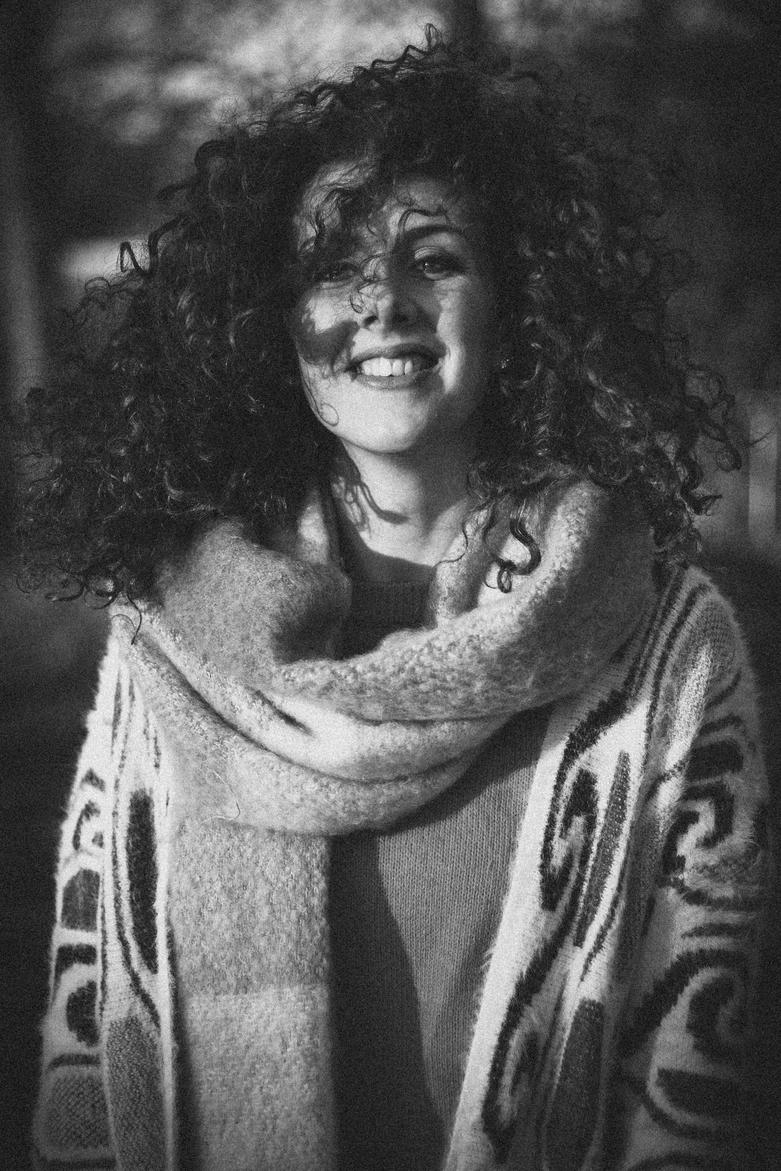 Woman wearing open cardigan and scarf grayscale photo