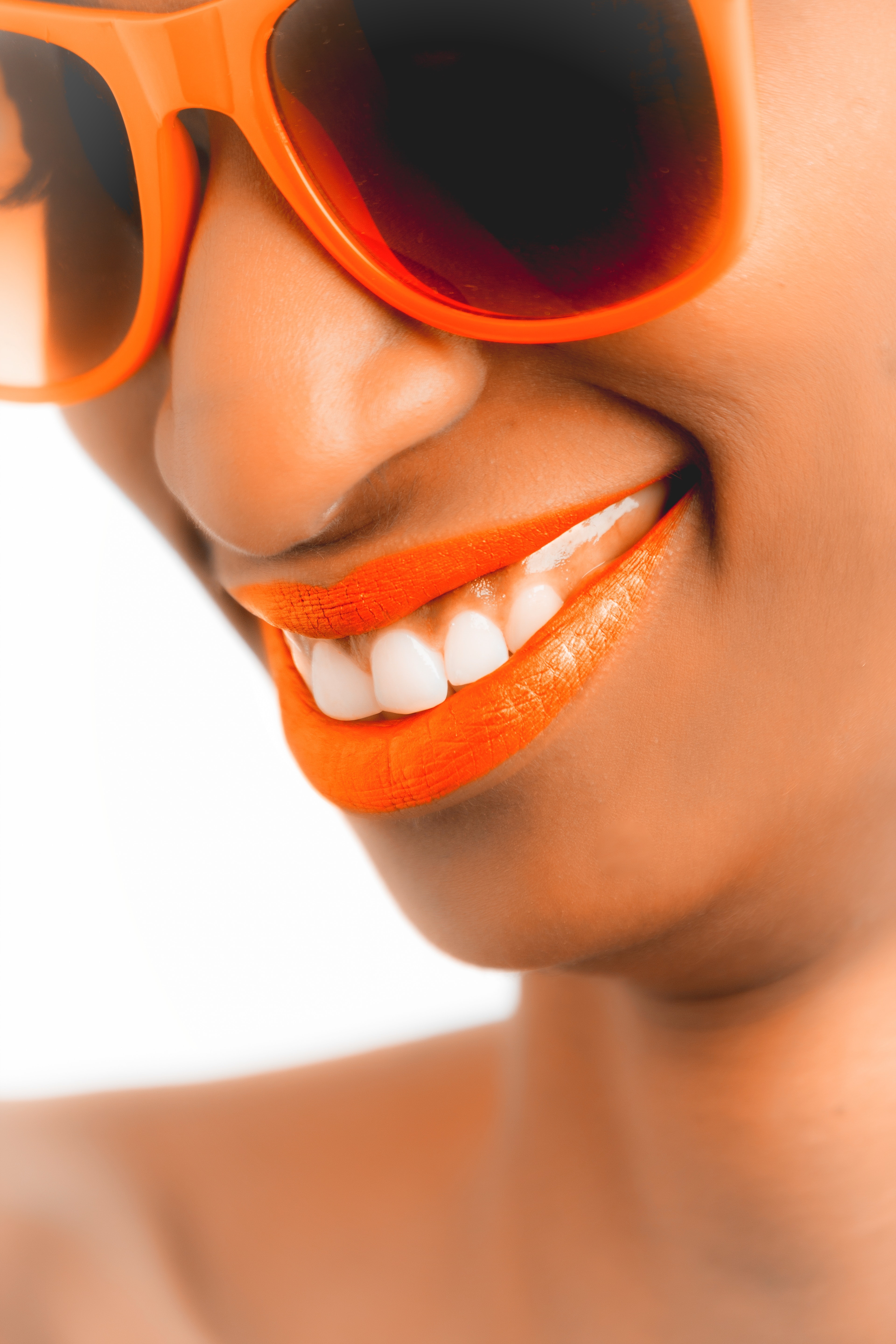 Woman wearing orange frame sunglasses and orange lipstick photo