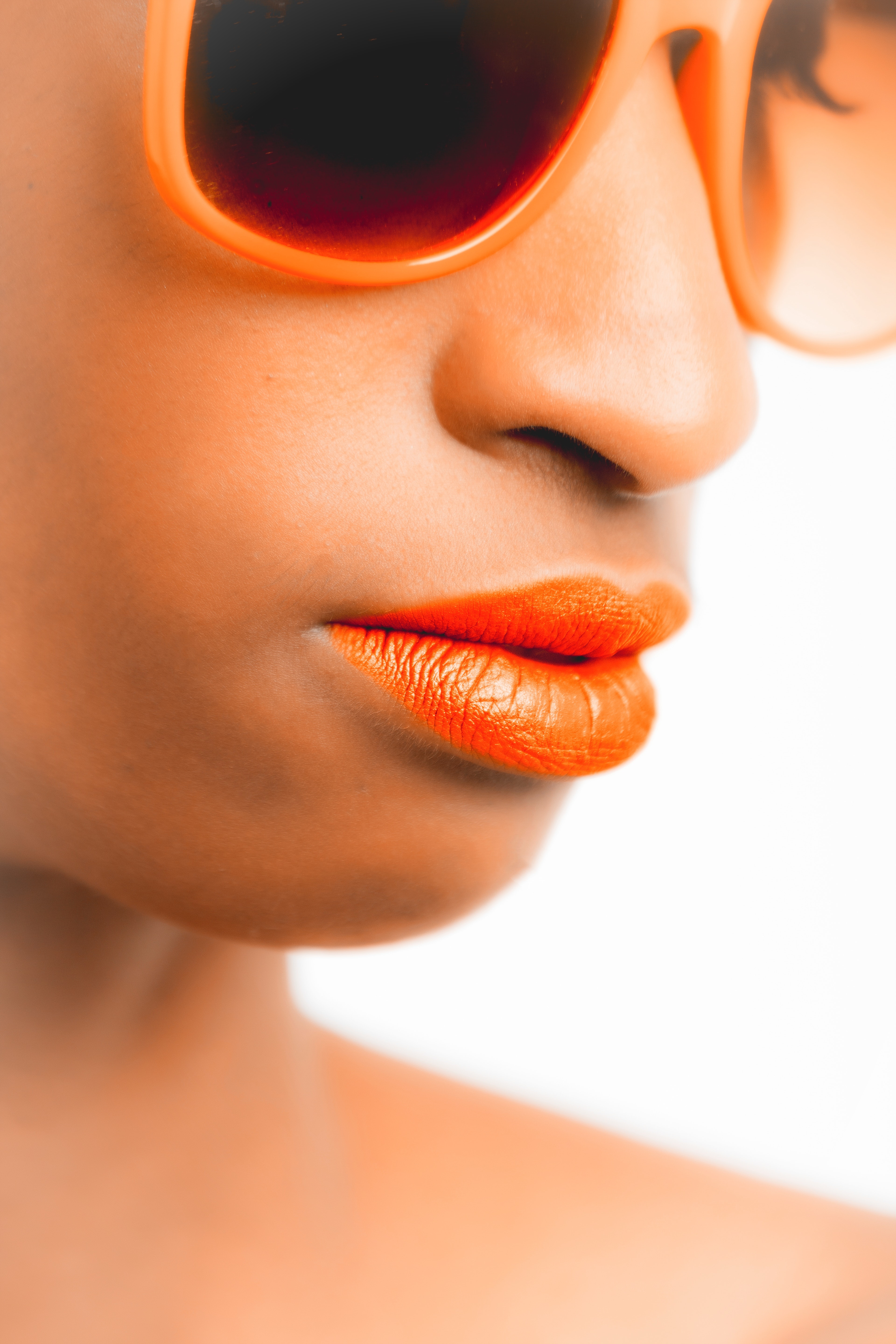 Woman wearing orange-framed sunglasses and orange lipstick photo