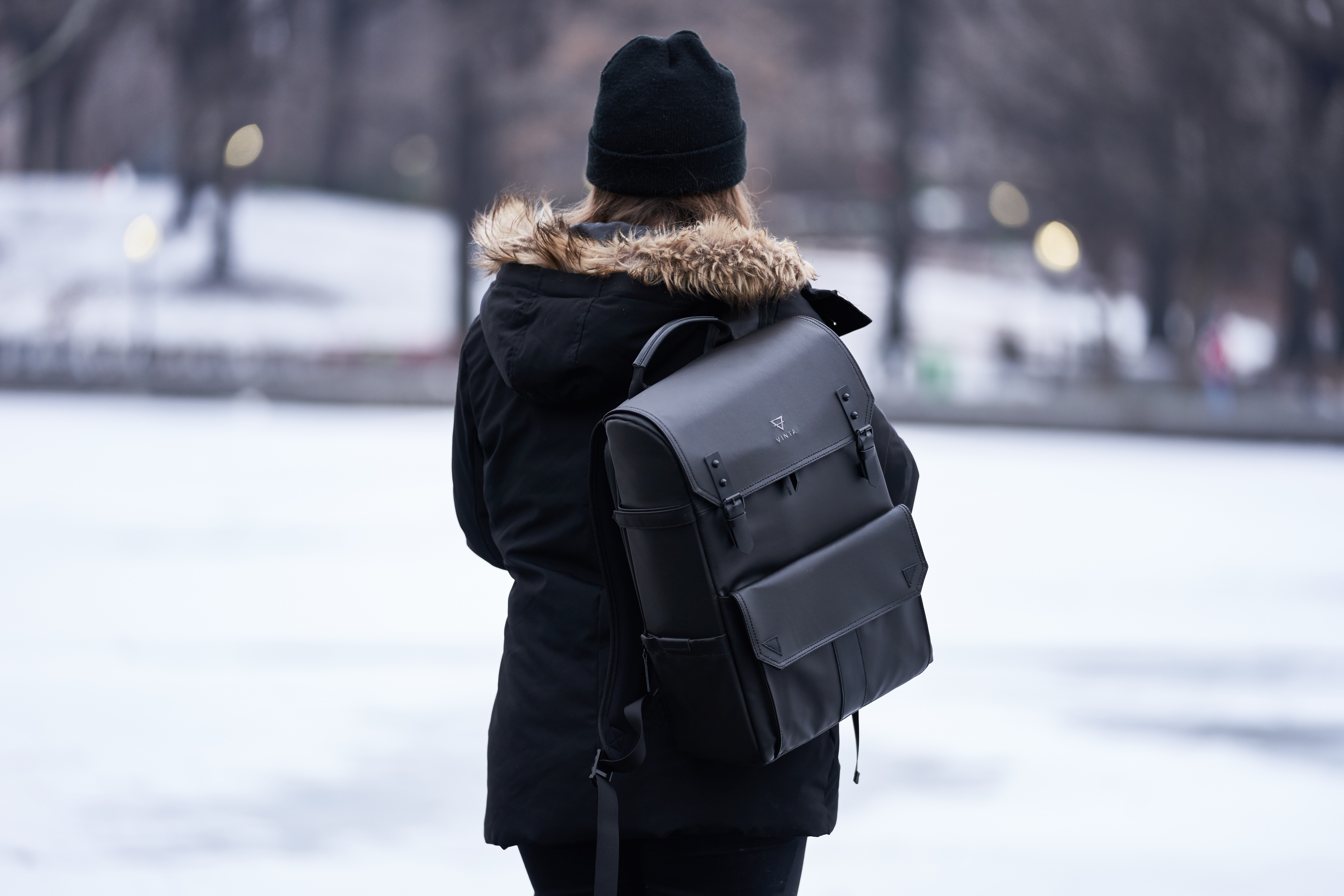 Woman wearing parka and carrying backpack during winter photo