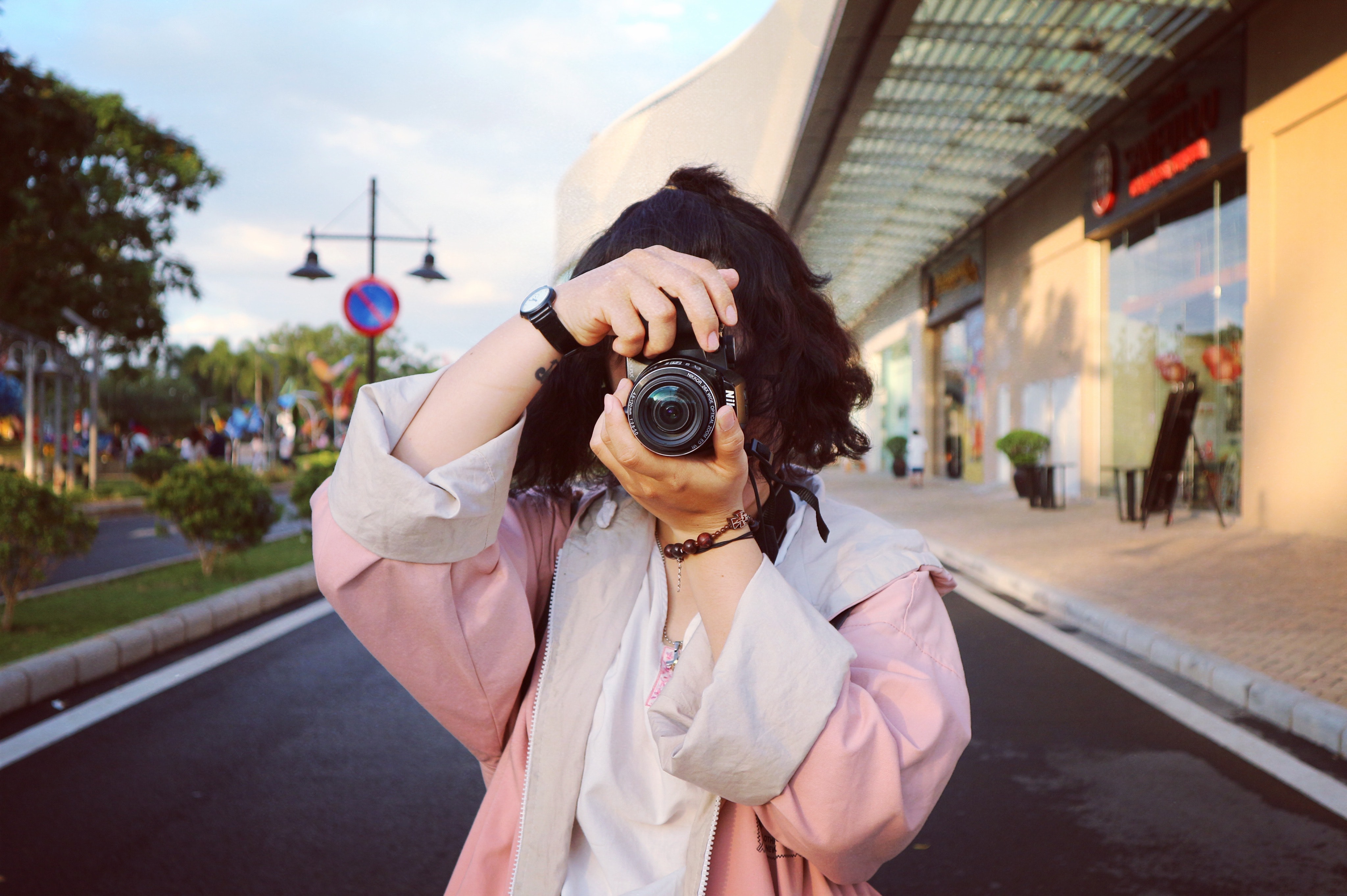 Woman wearing pink coat holding dslr camera photo