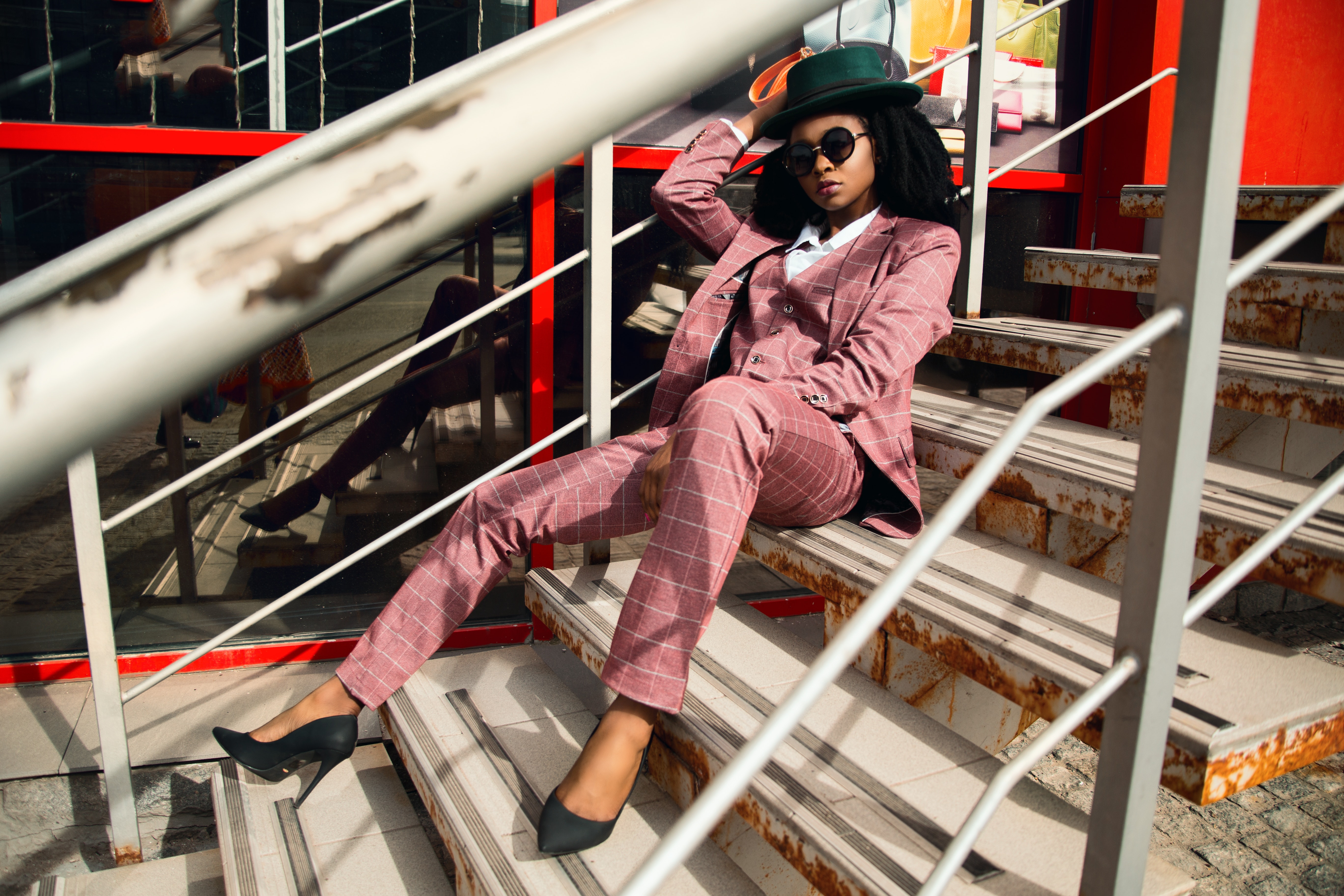 Woman wearing pink suit jacket and pants sitting on staircase photo