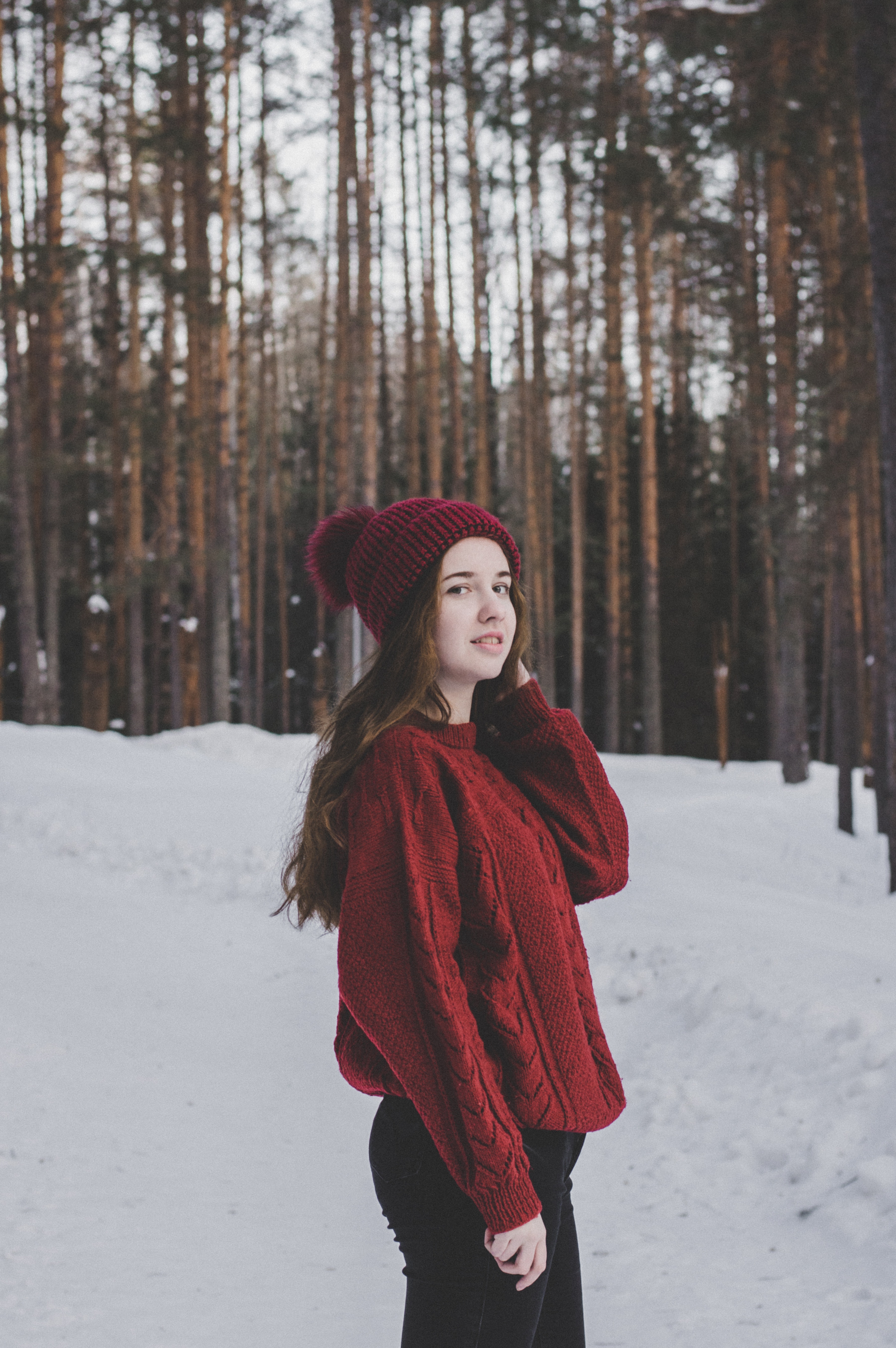 Woman wearing red sweater and red beanie under forest photo