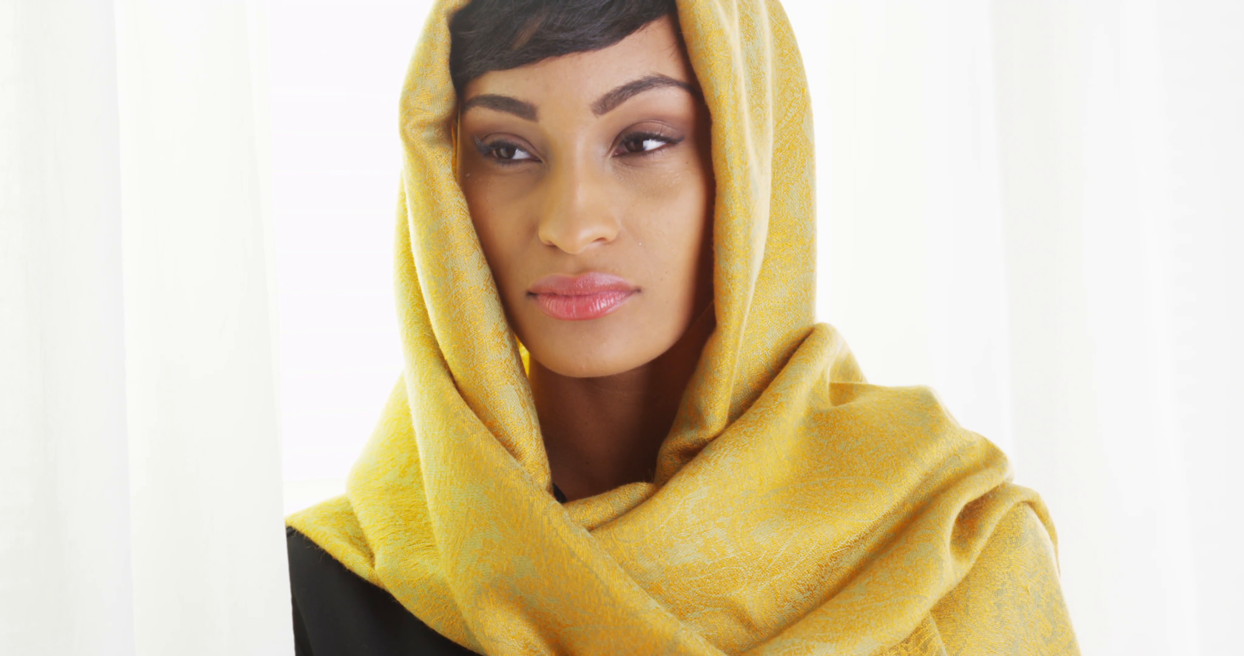 Black woman wearing gold head scarf by bright window Stock Video ...