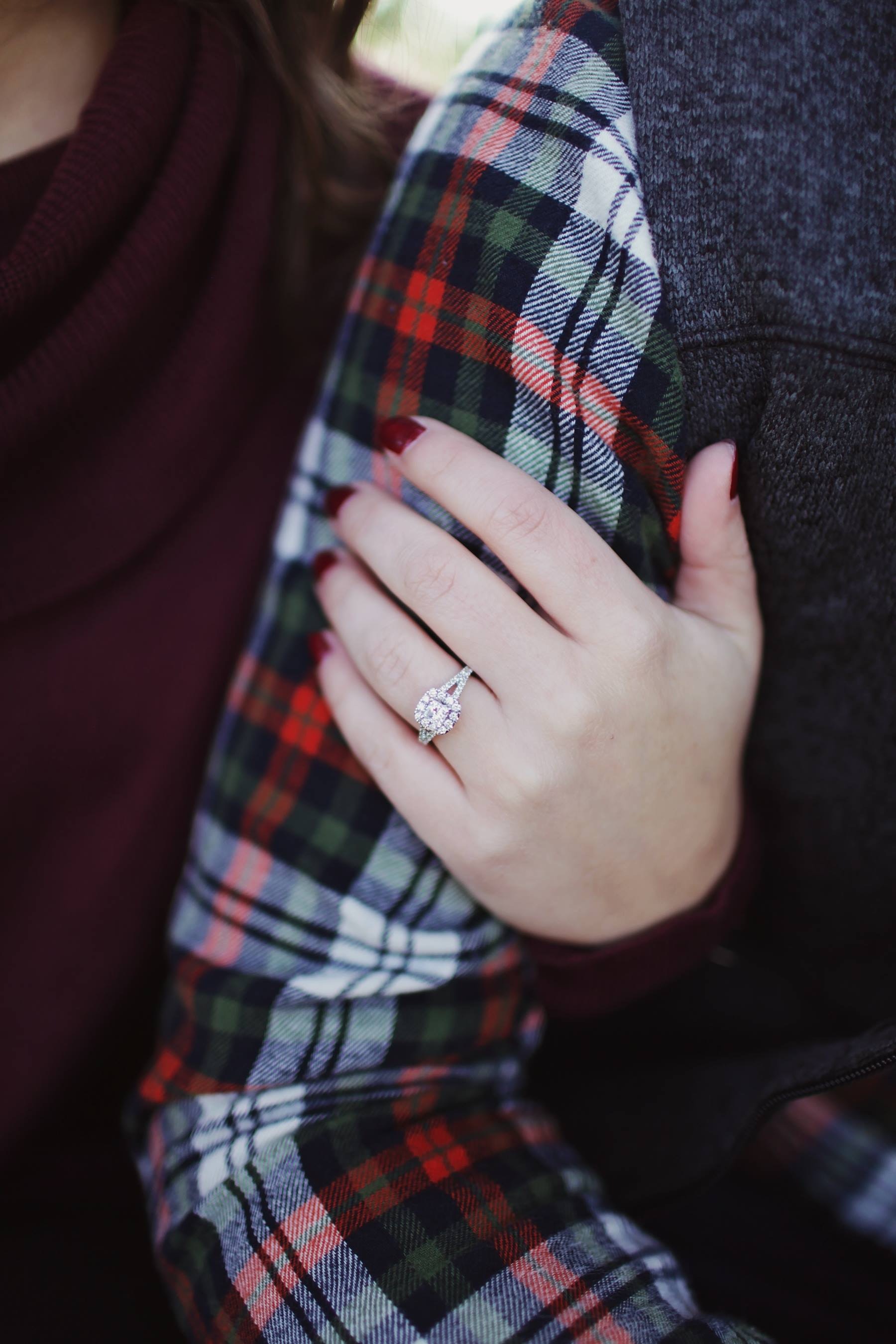 Woman wearing silver-colored solitaire ring holding person's arm photo