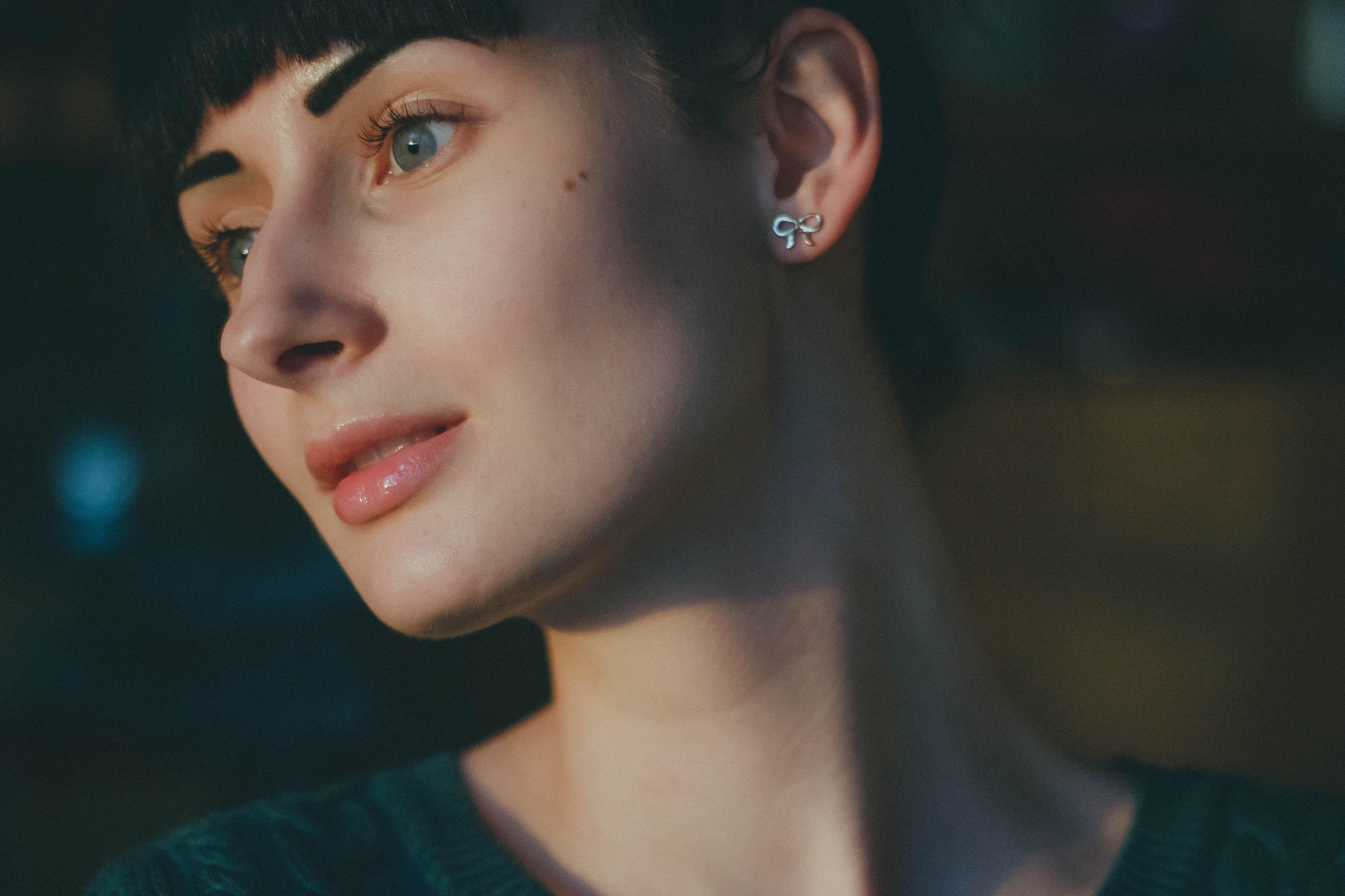 Woman wearing silver earrings and green shirt photo