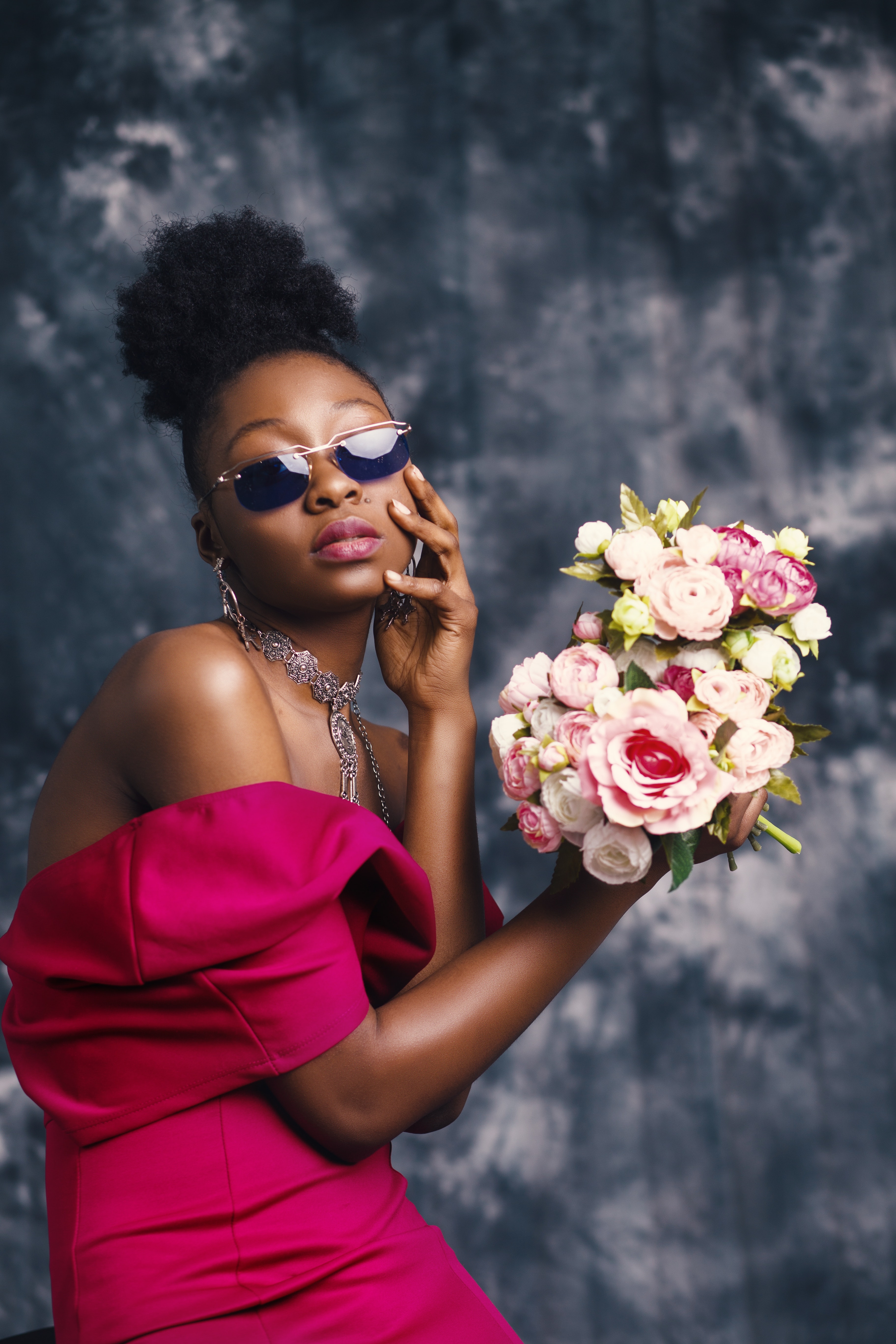 Woman wearing sunglasses and posing for pic with flowers photo