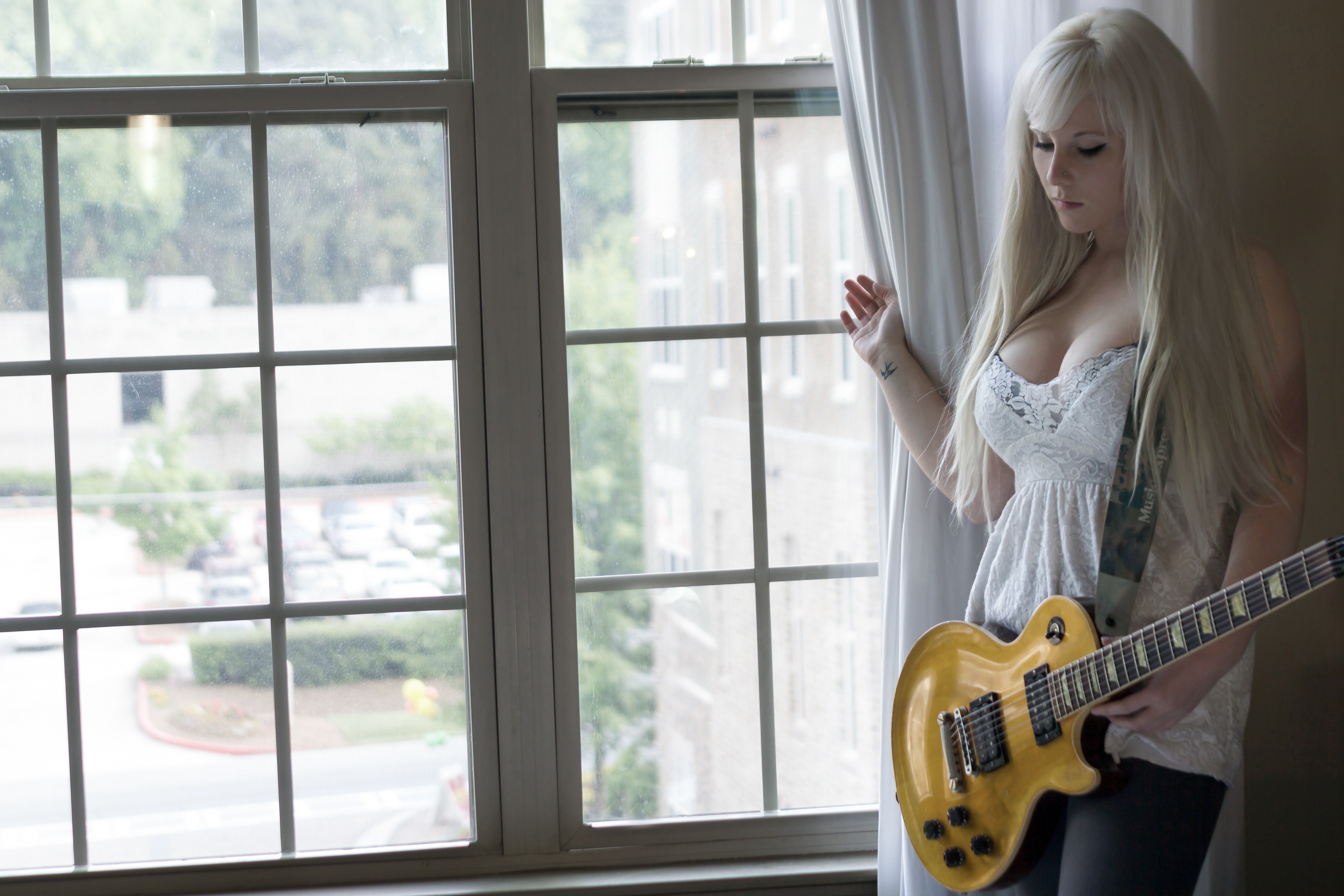 Woman wearing white dress holding electric guitar photo