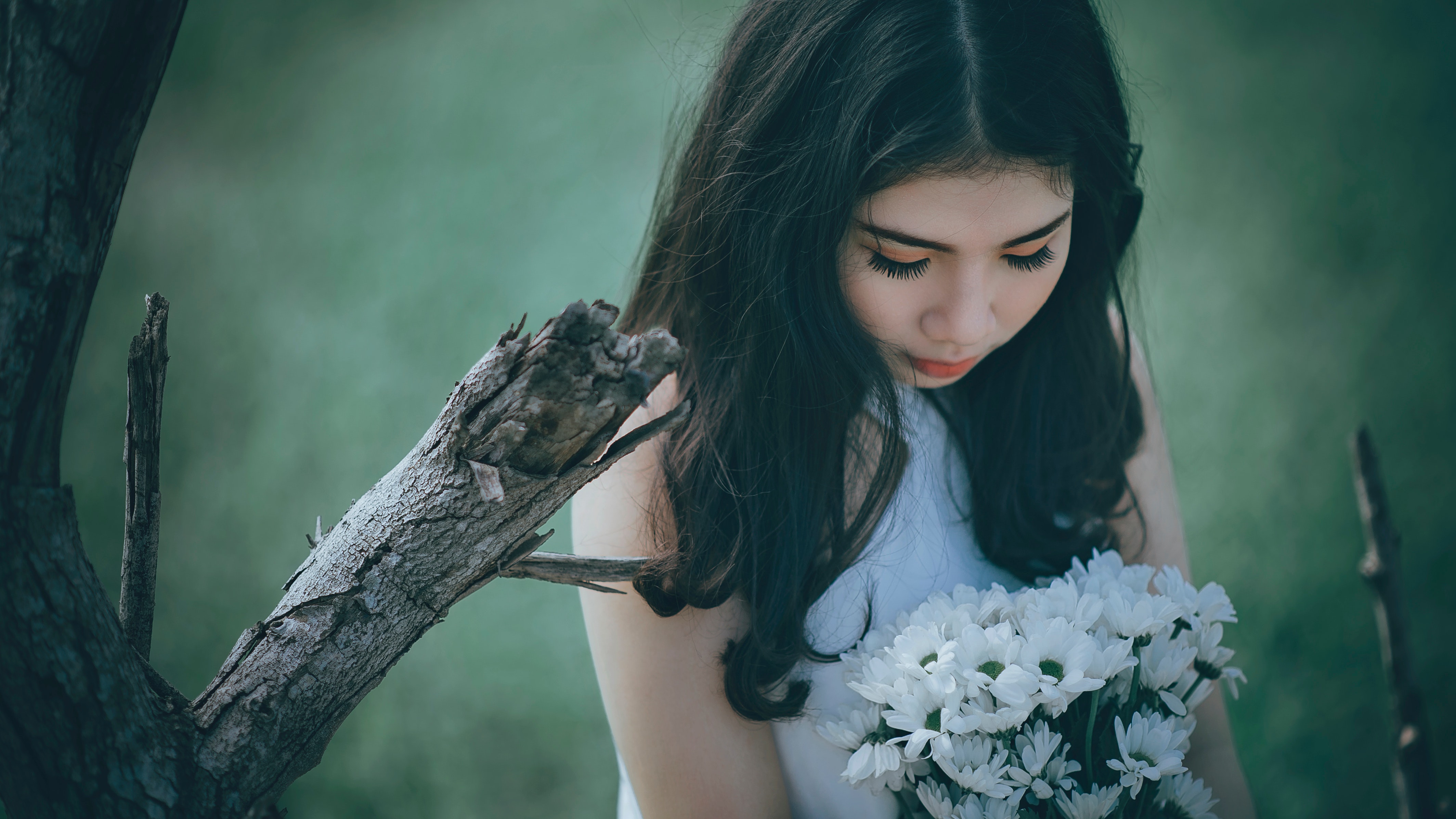 Woman wearing white halter top holding white flower bouquet photo