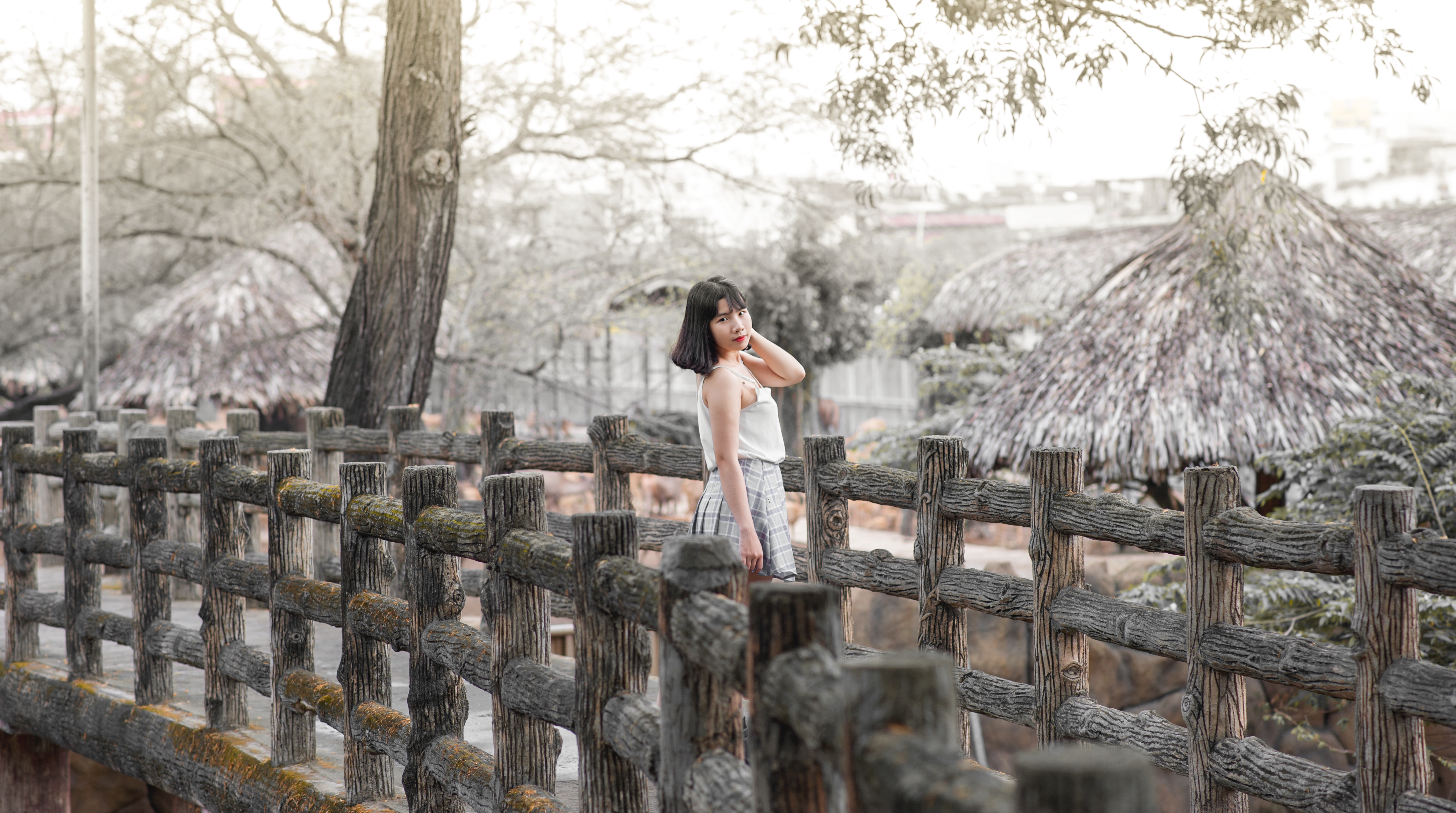 Woman wearing white sleeveless dress standing on gray wooden dock photo