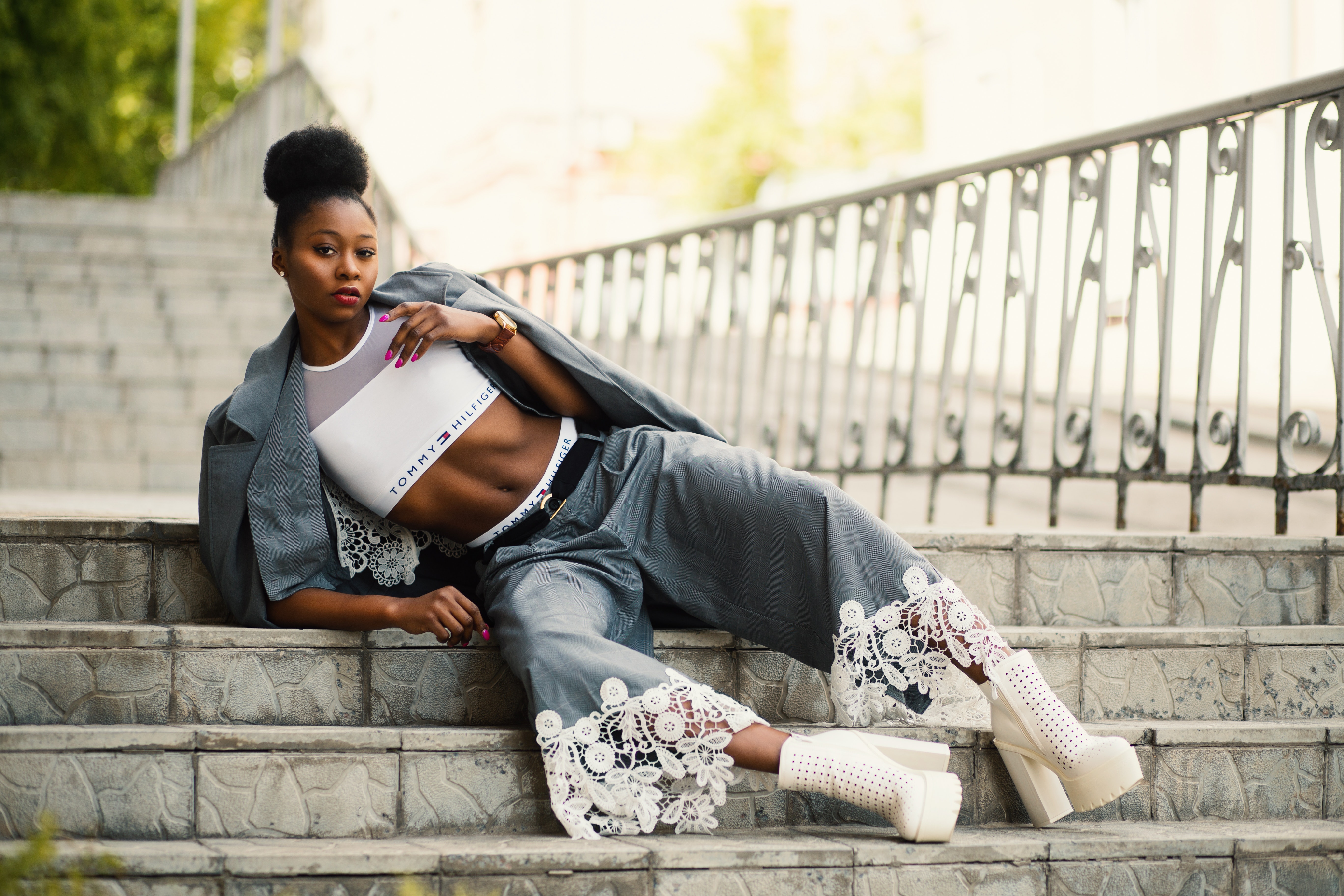 Woman wearing white sports bra and gray pants laying on stairway photo