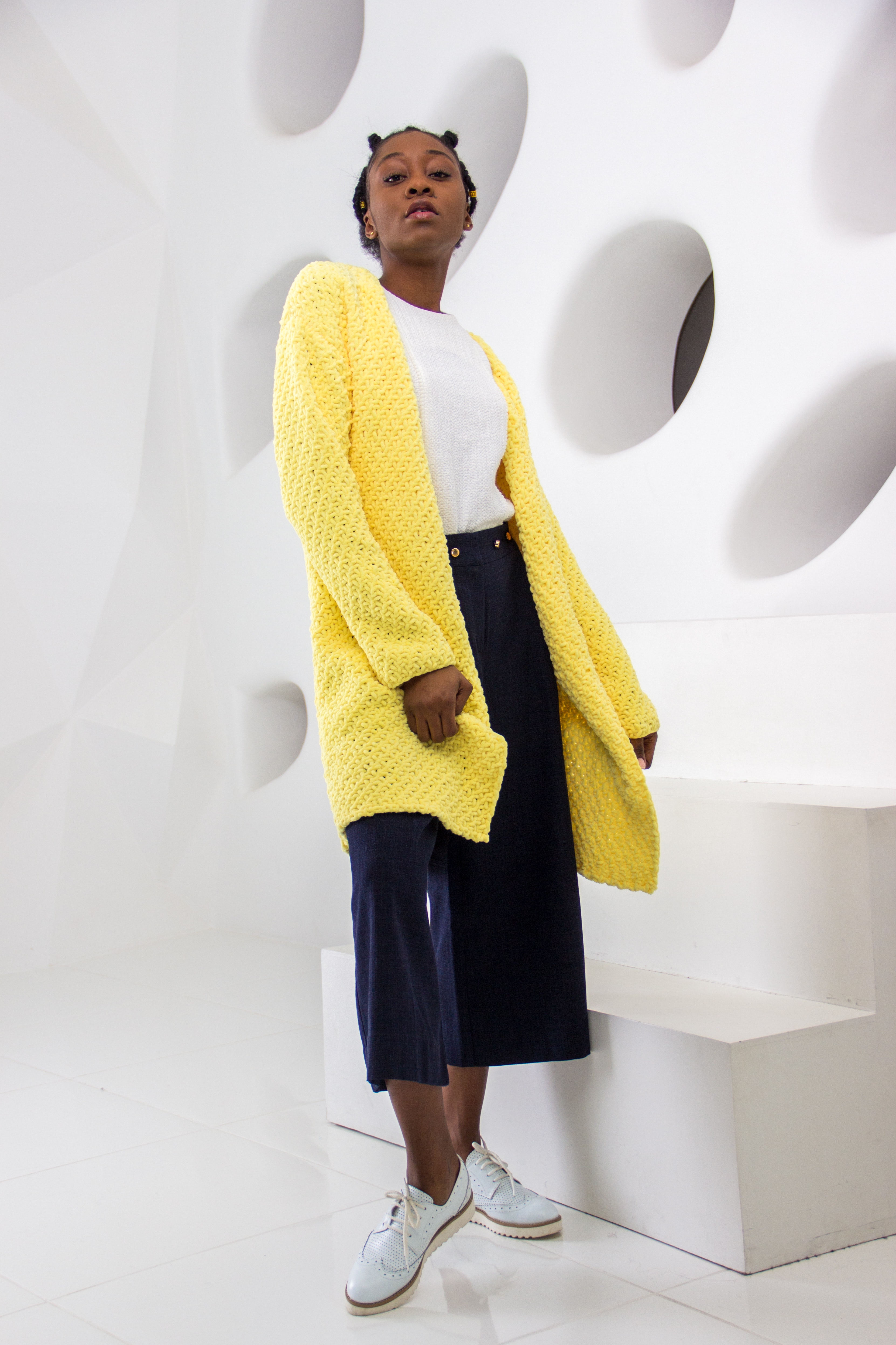 Woman wearing yellow knit cardigan standing photo