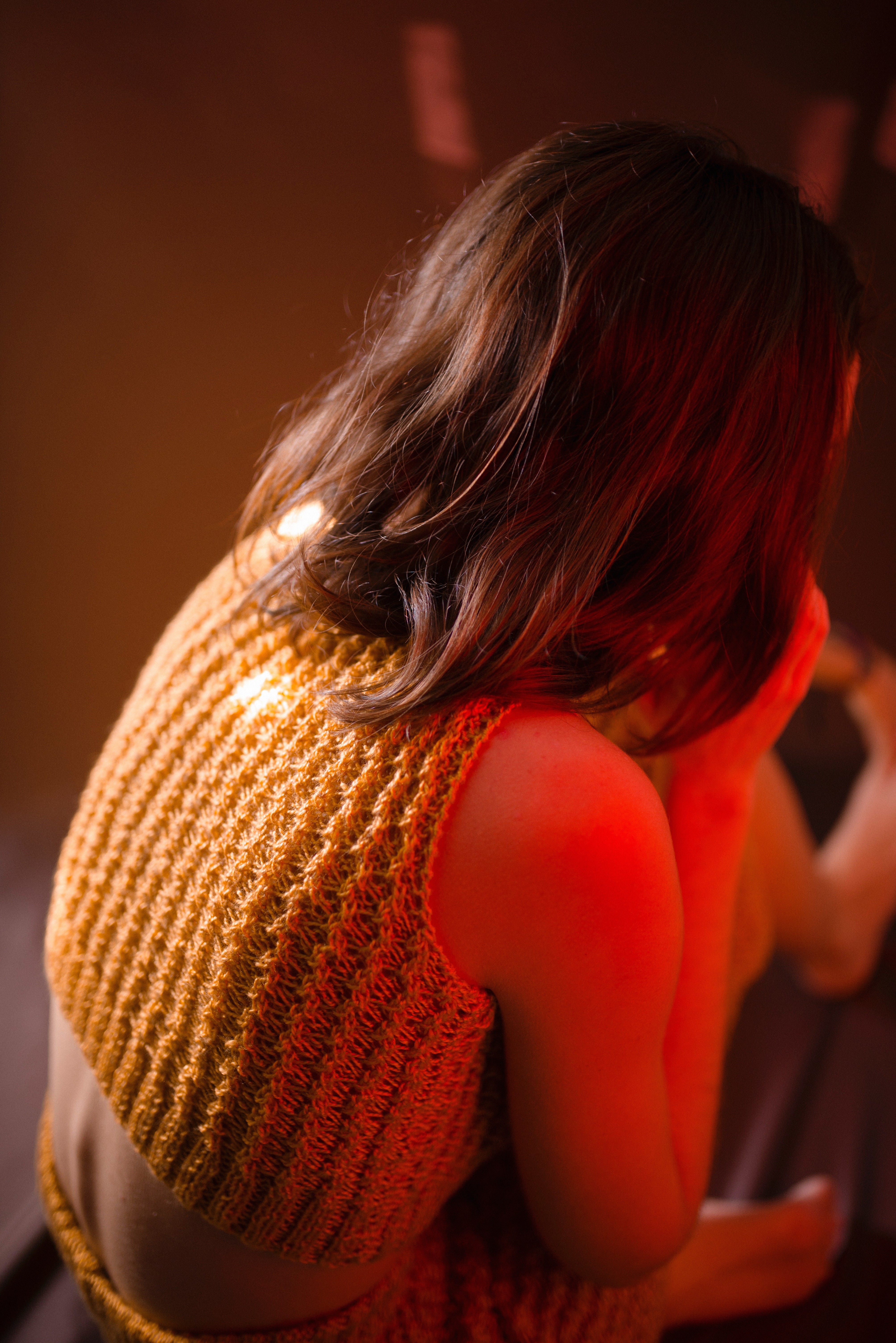 Woman wearing yellow knitted crop-top shirt sitting on floor photo