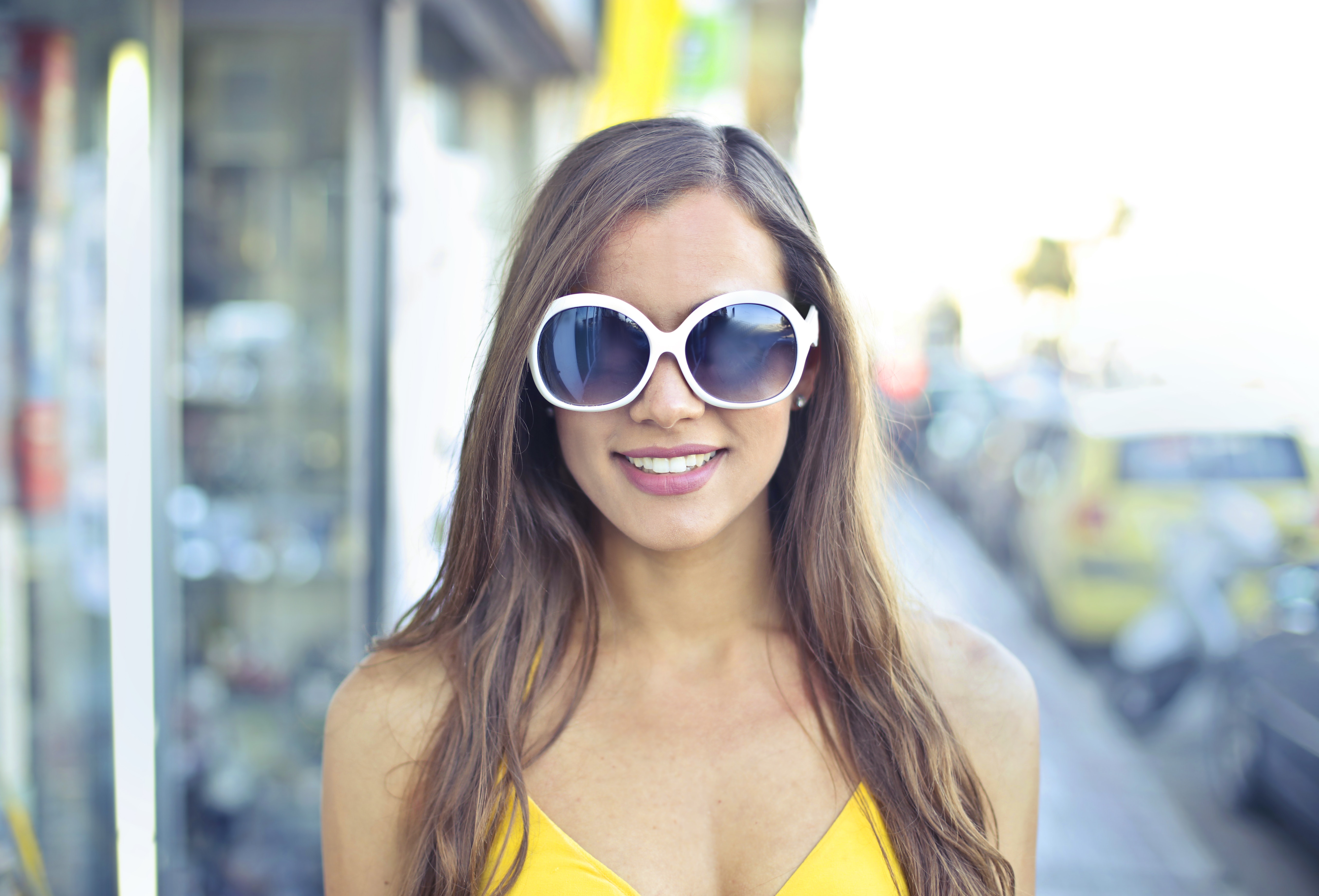 Woman wearing yellow spaghetti strap top and round sunglasses photo