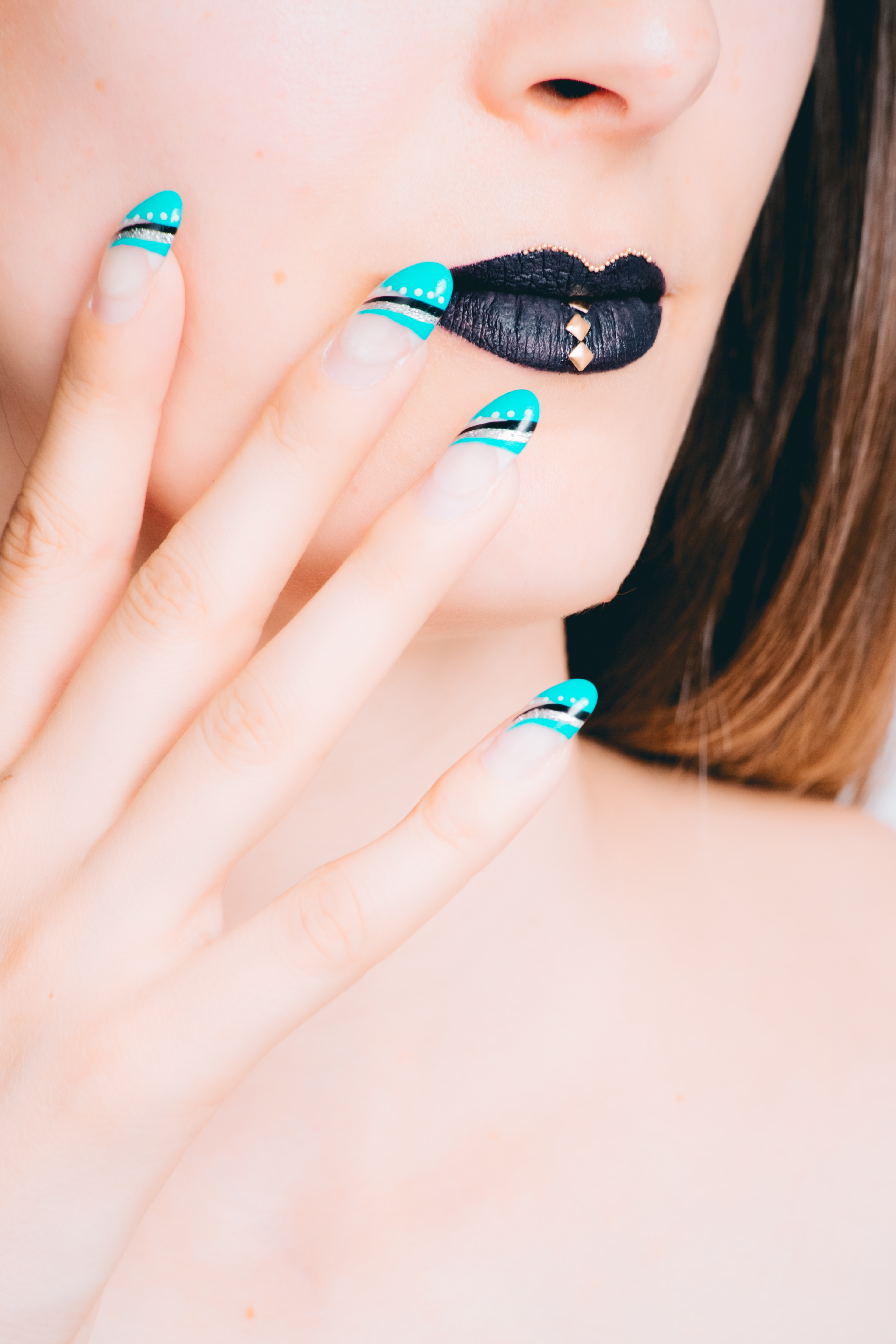 Woman with black lipstick and teal manicure photo