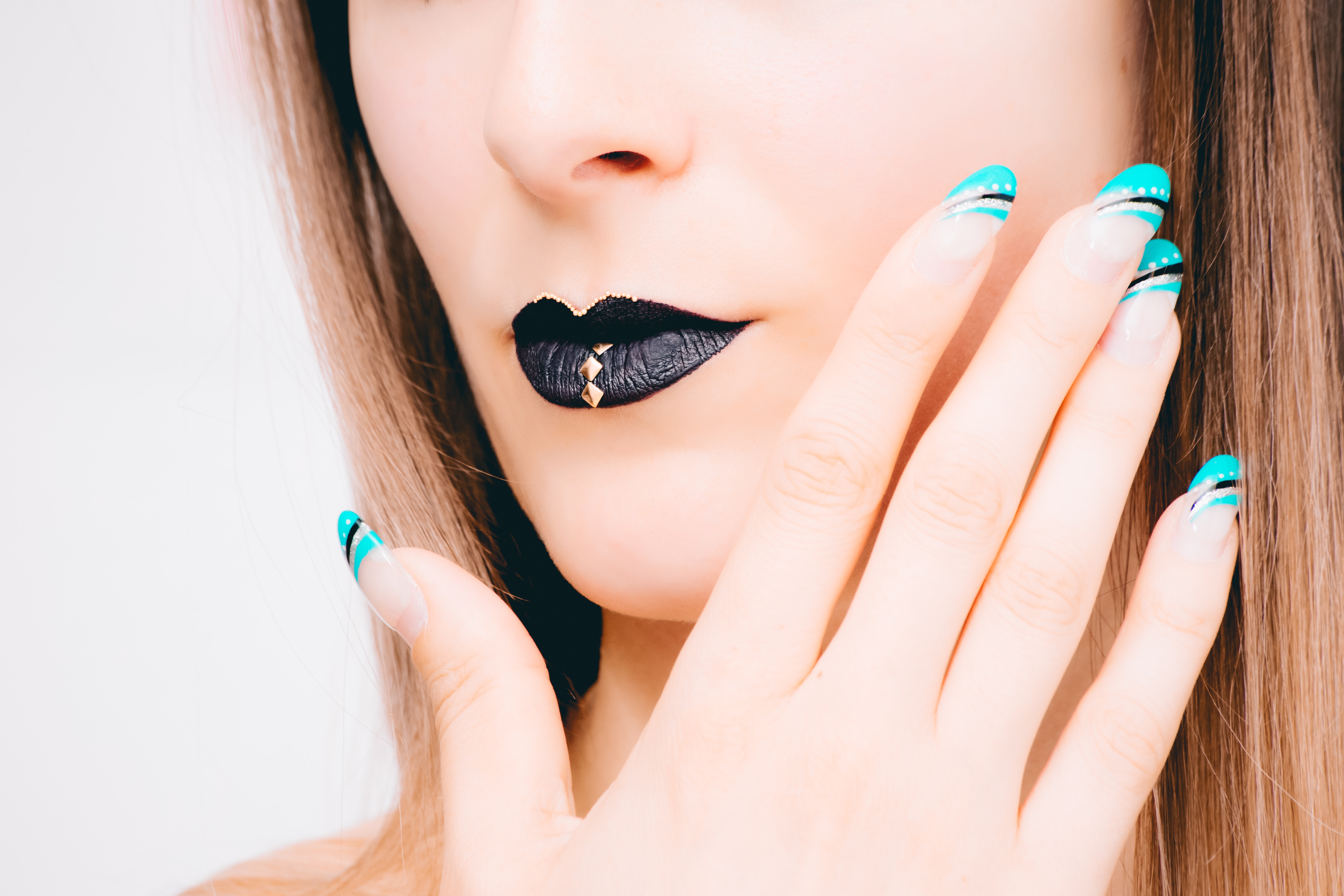 Woman with black lipstick and teal nail polish photo