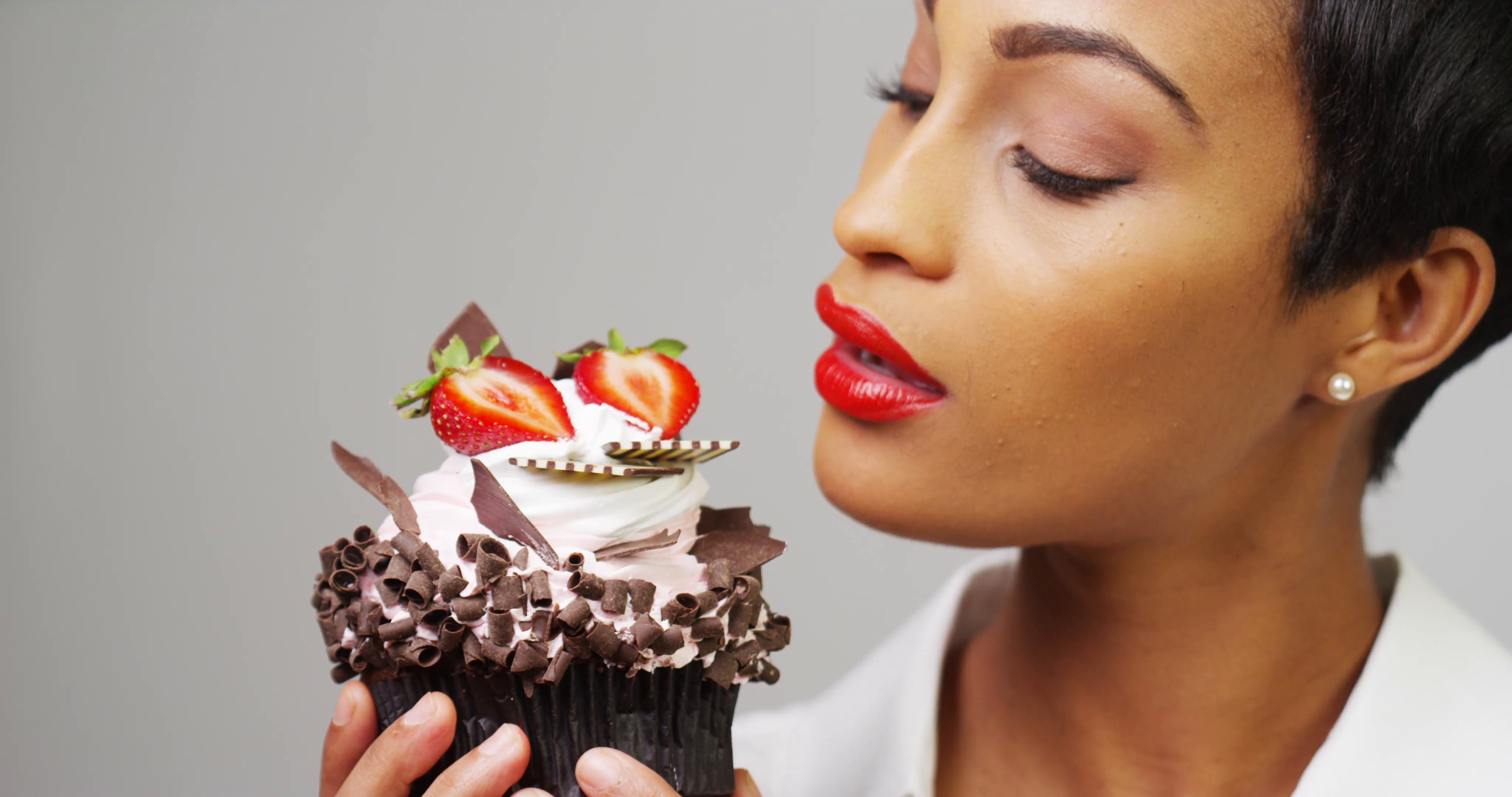 Black woman admiring a fancy dessert cupcake with chocolate and ...
