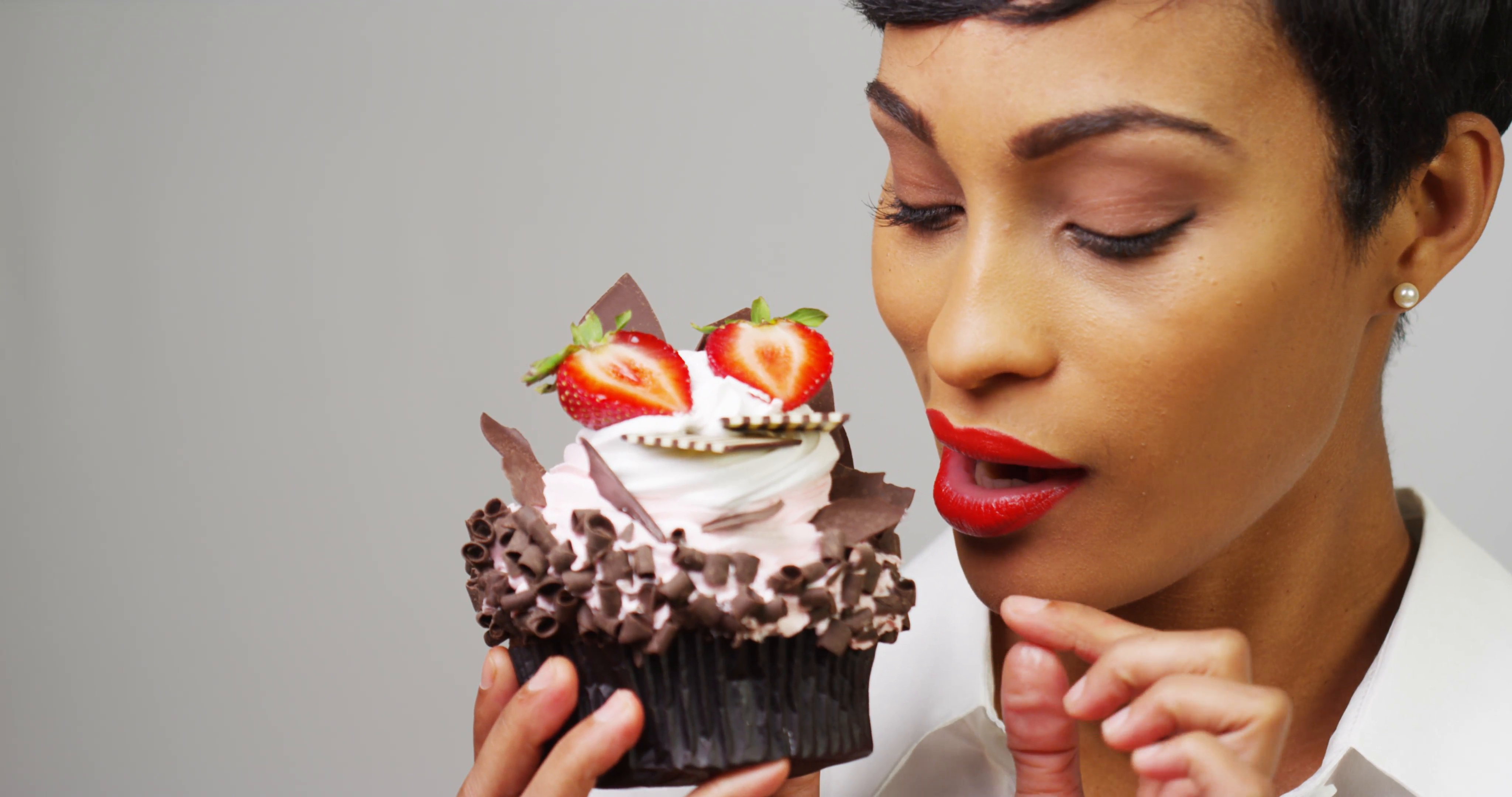 Woman admiring a fancy dessert cupcake with chocolate and ...