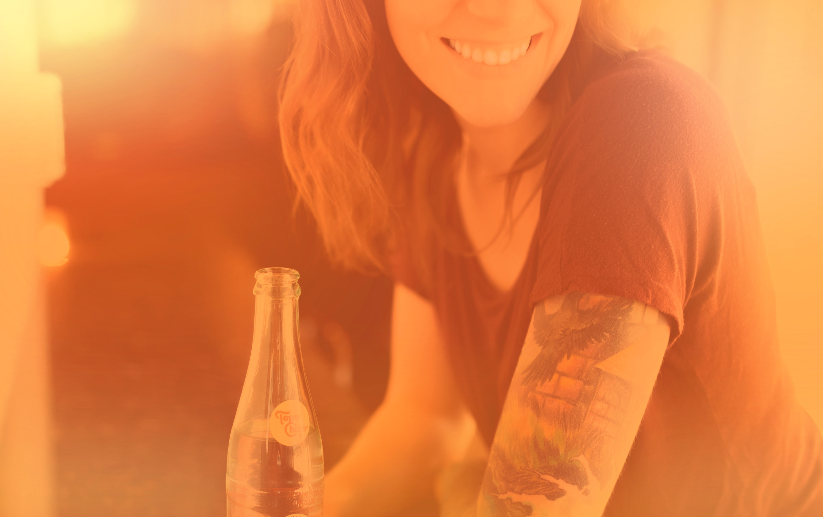 Woman with drink smiling - colorized hazy effect photo