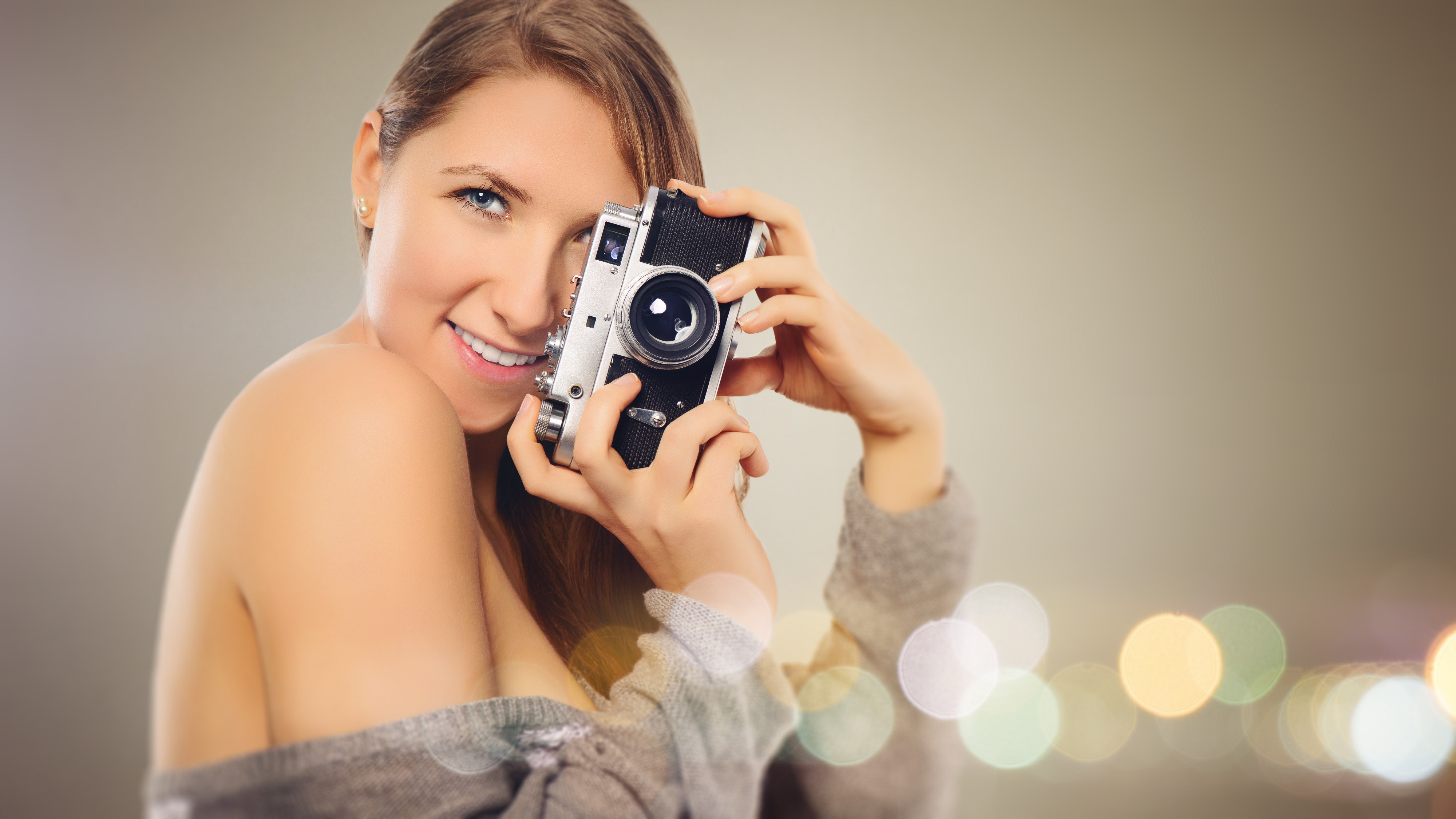 Woman with gray dress holding camera photo