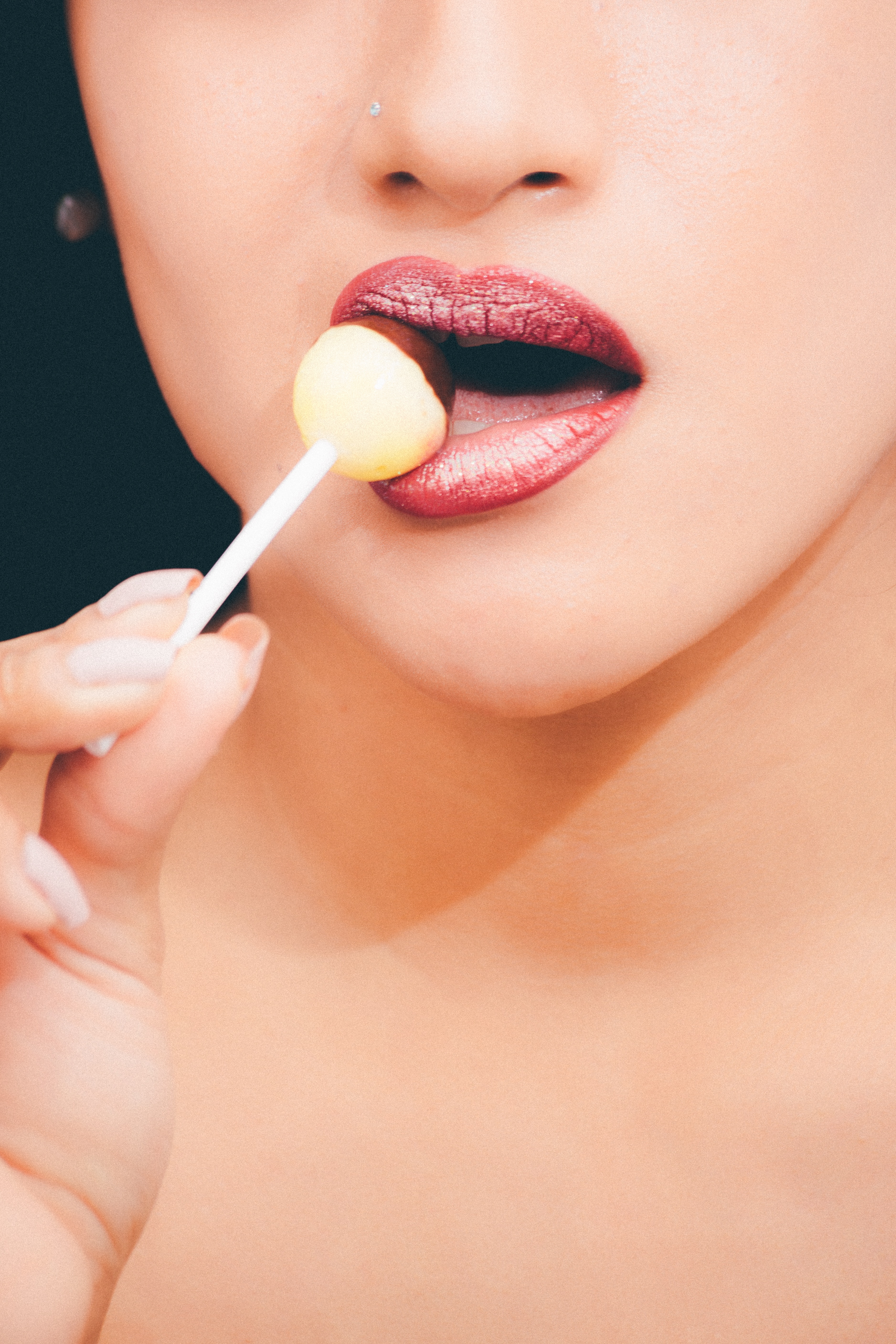 Woman with red lipstick licking a lollipop photo