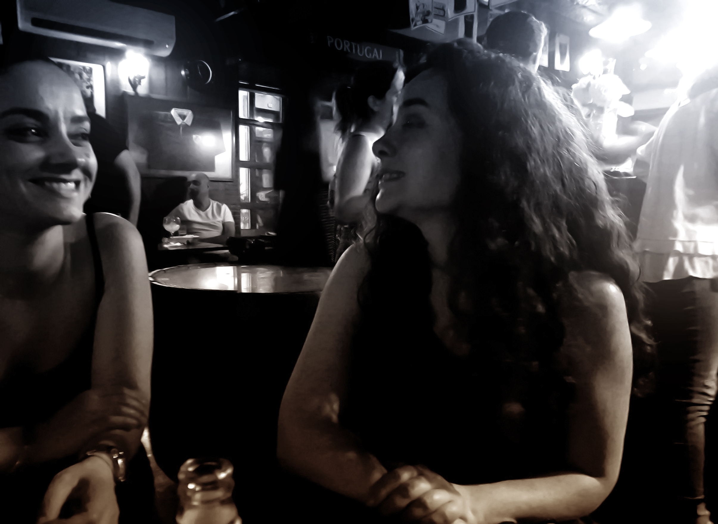 Women at a bar talking and smiling - retro - dark fuzzy looks photo