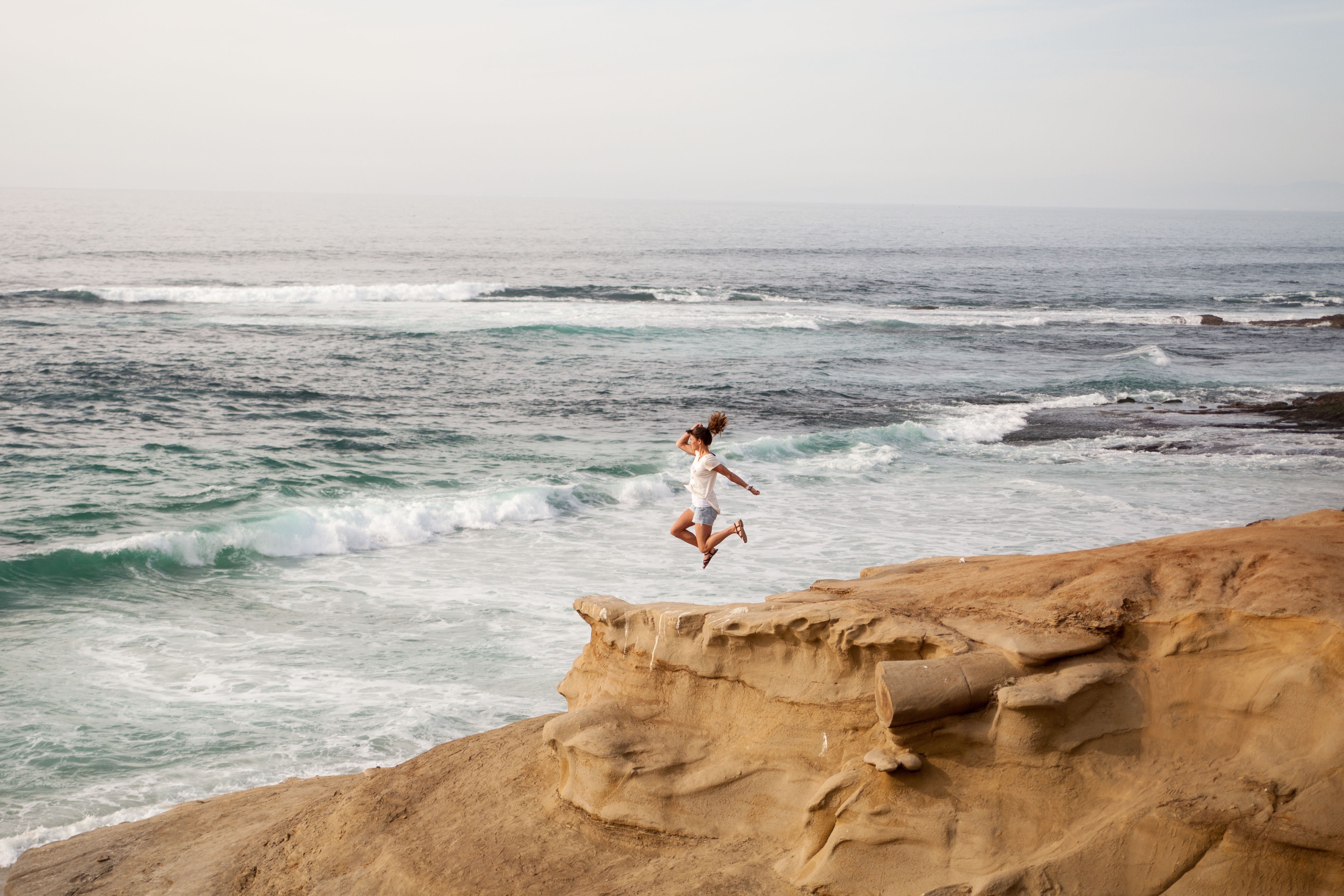 Women wearing white shirt jumping on shore photo