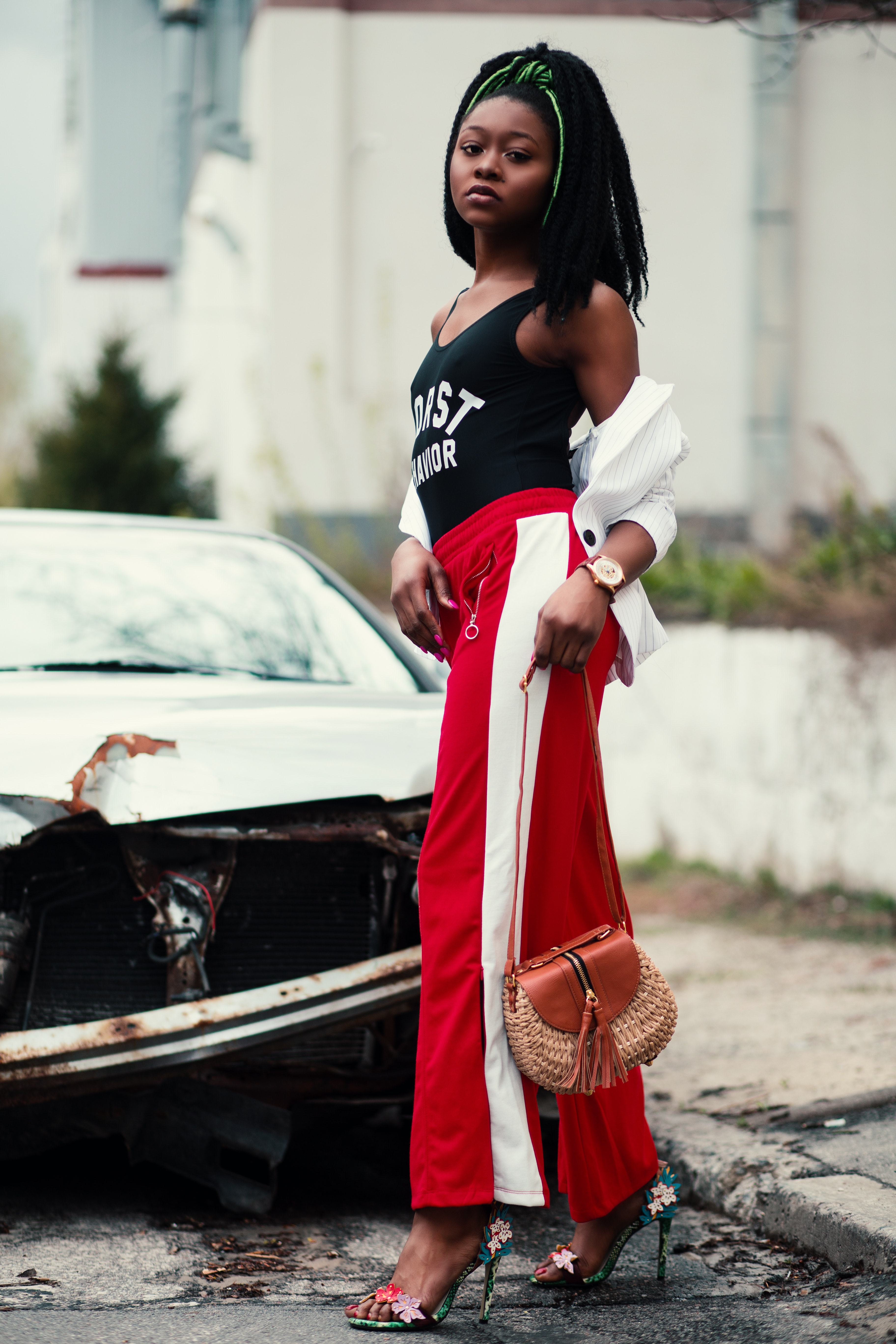 Women's black tank top and red track pants walking on street photo