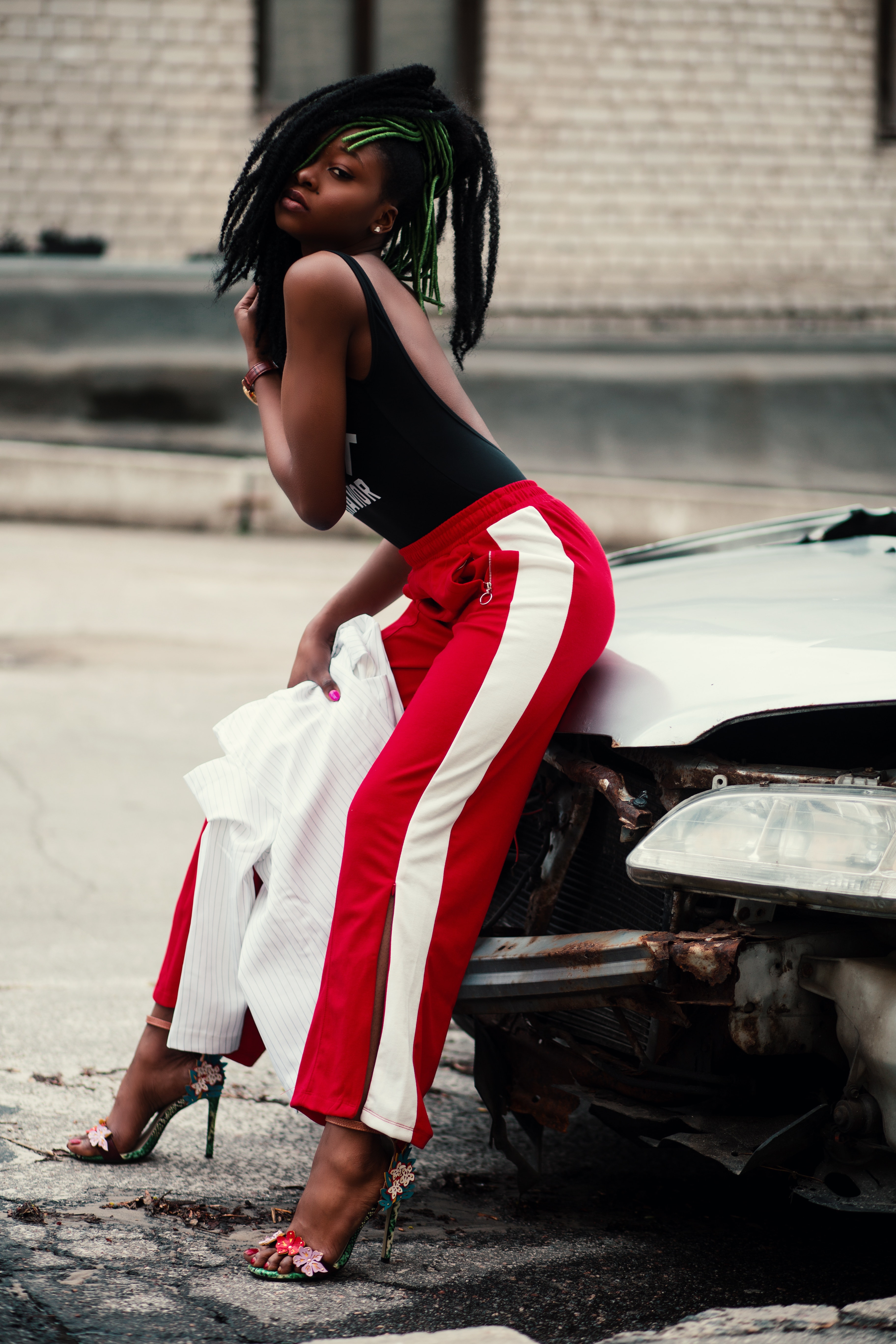 Women's wearing black backless top with red and white pants photo