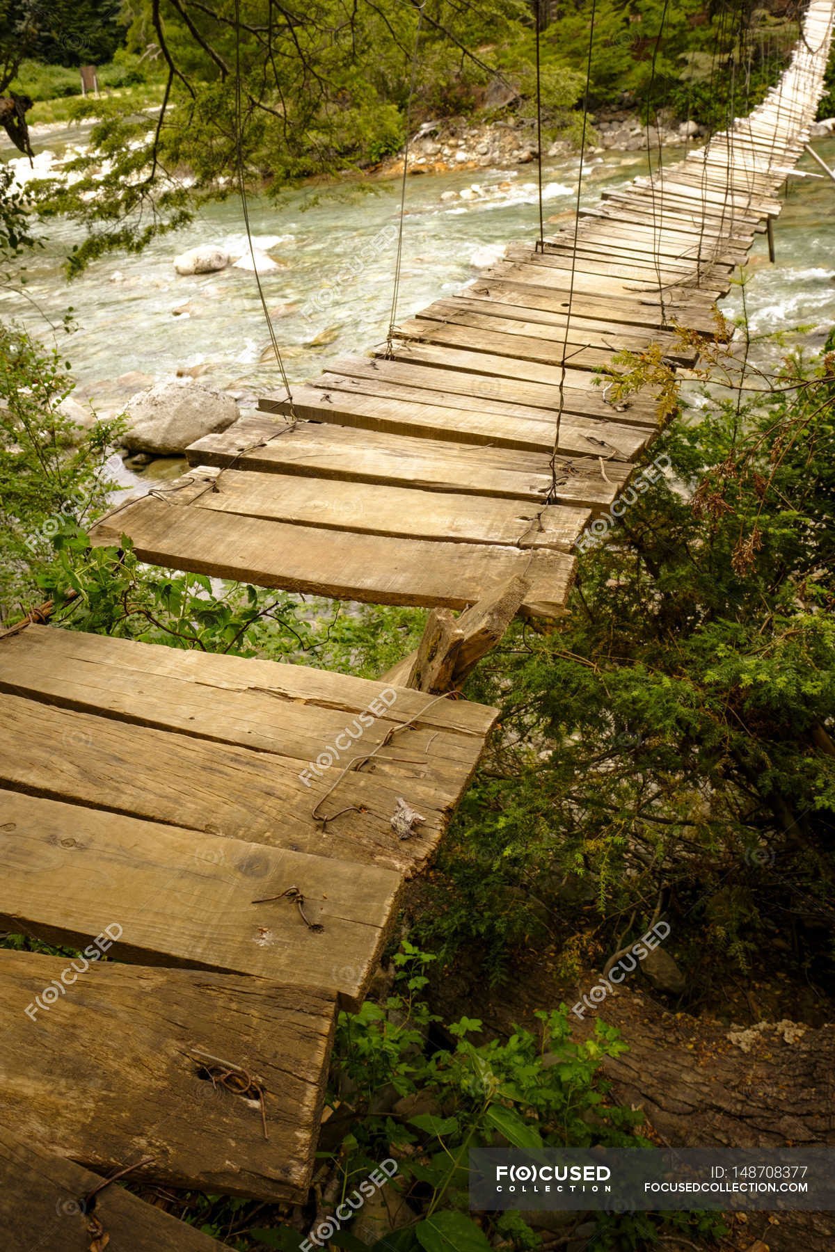 Wooden bridge over mountain river — Stock Photo | #148708377