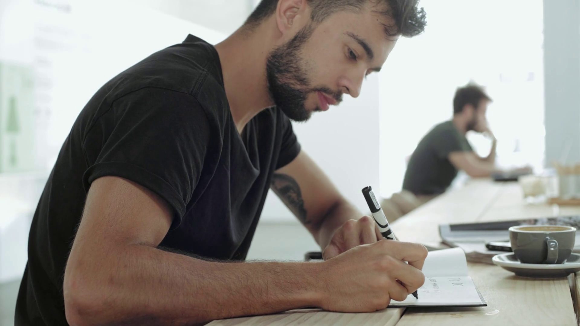 Side view of serious attractive man writing important plan for his ...