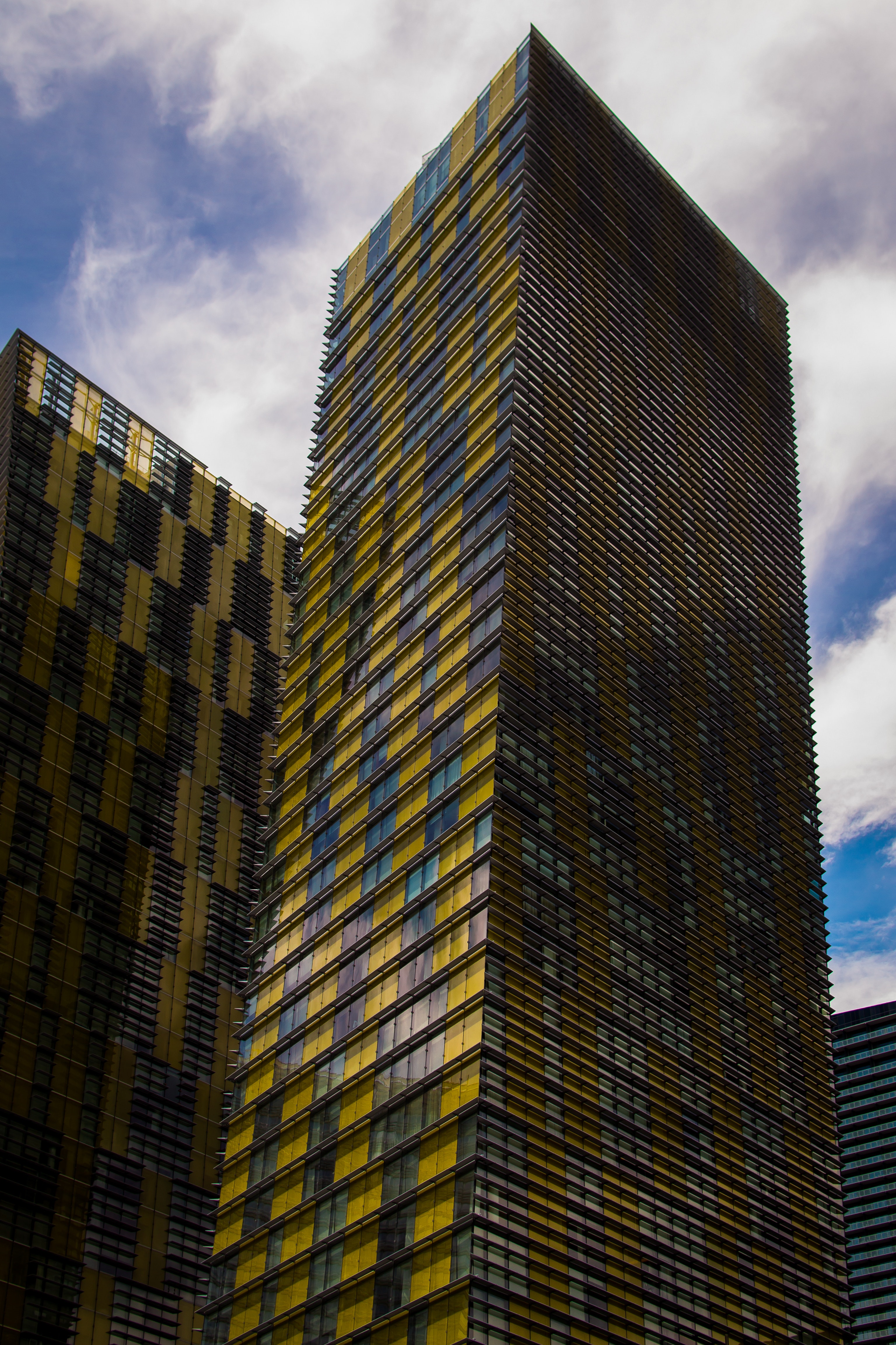 Yellow and gray high rise buildings under blue and white sunny cloudy sky photo