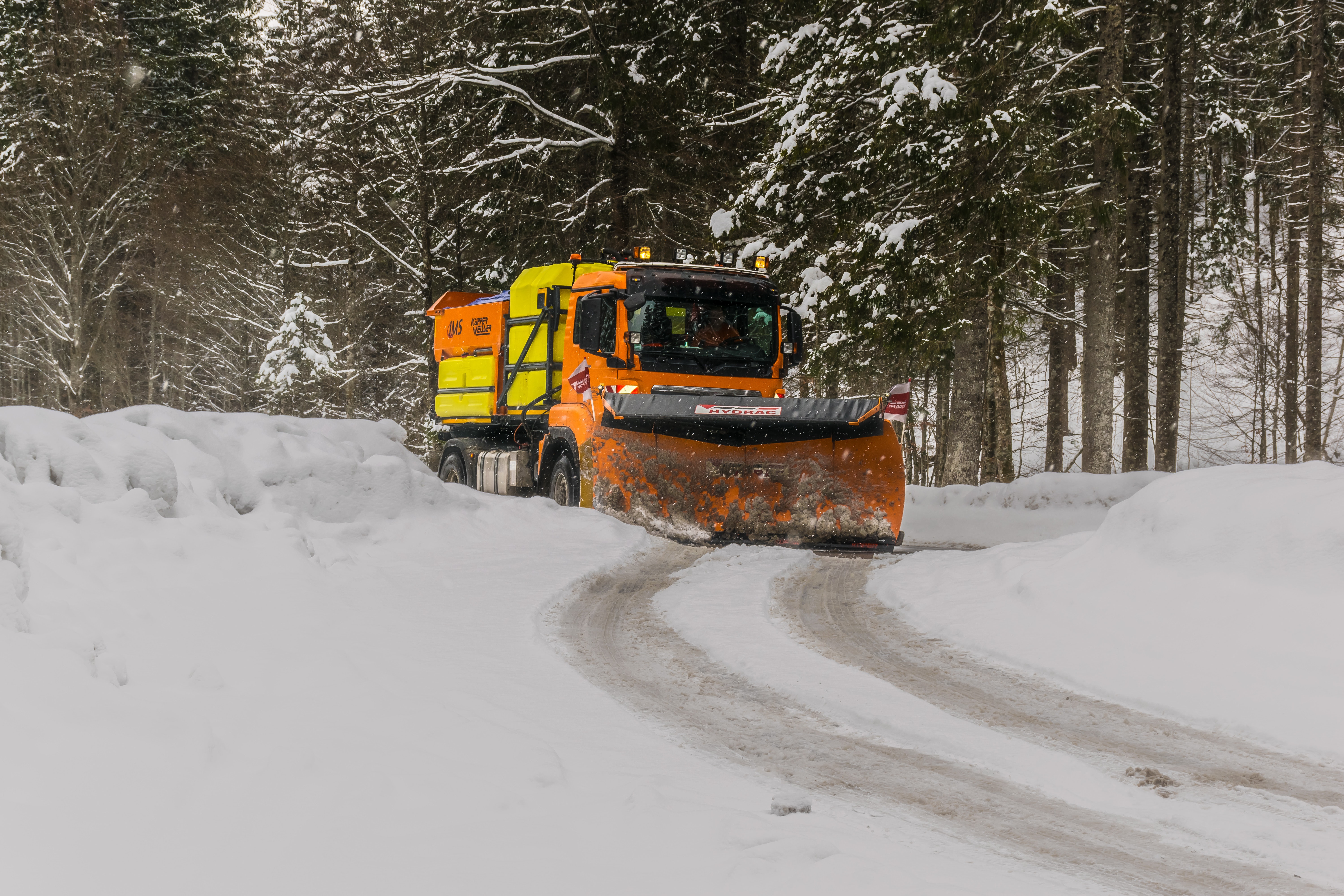 Yellow, orange, and black truck plowing snow photo