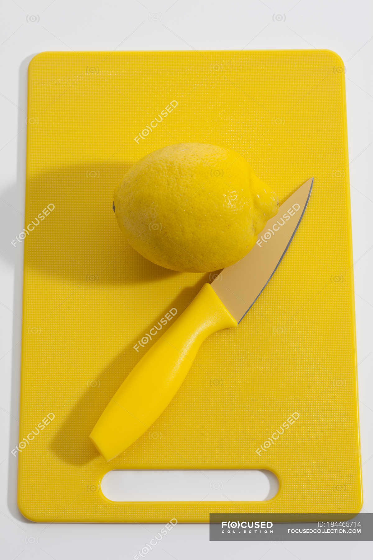 Fresh lemon on yellow plastic board with yellow knife — Stock Photo ...