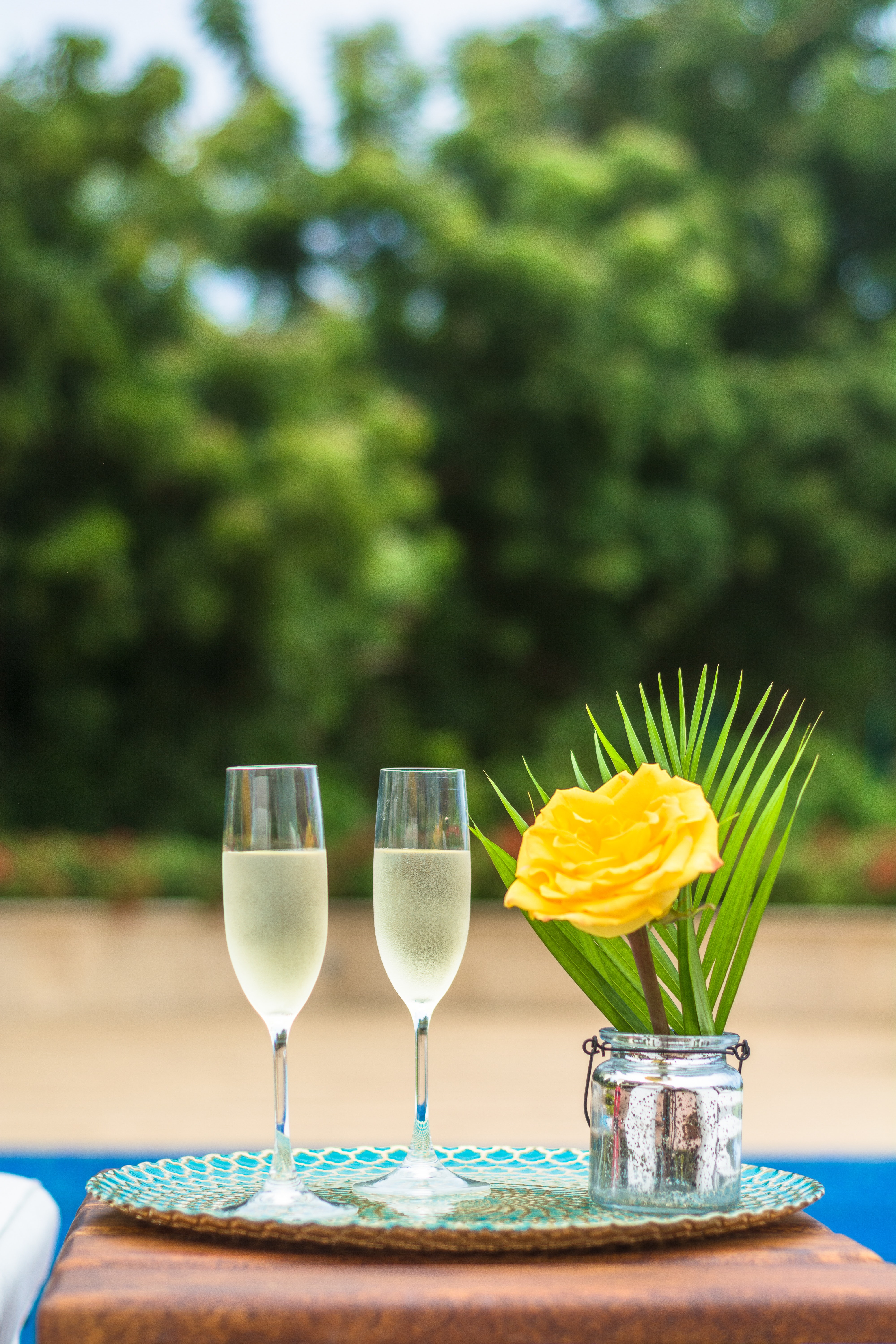 Yellow rose flower centerpiece and two clear champagne flutes photo