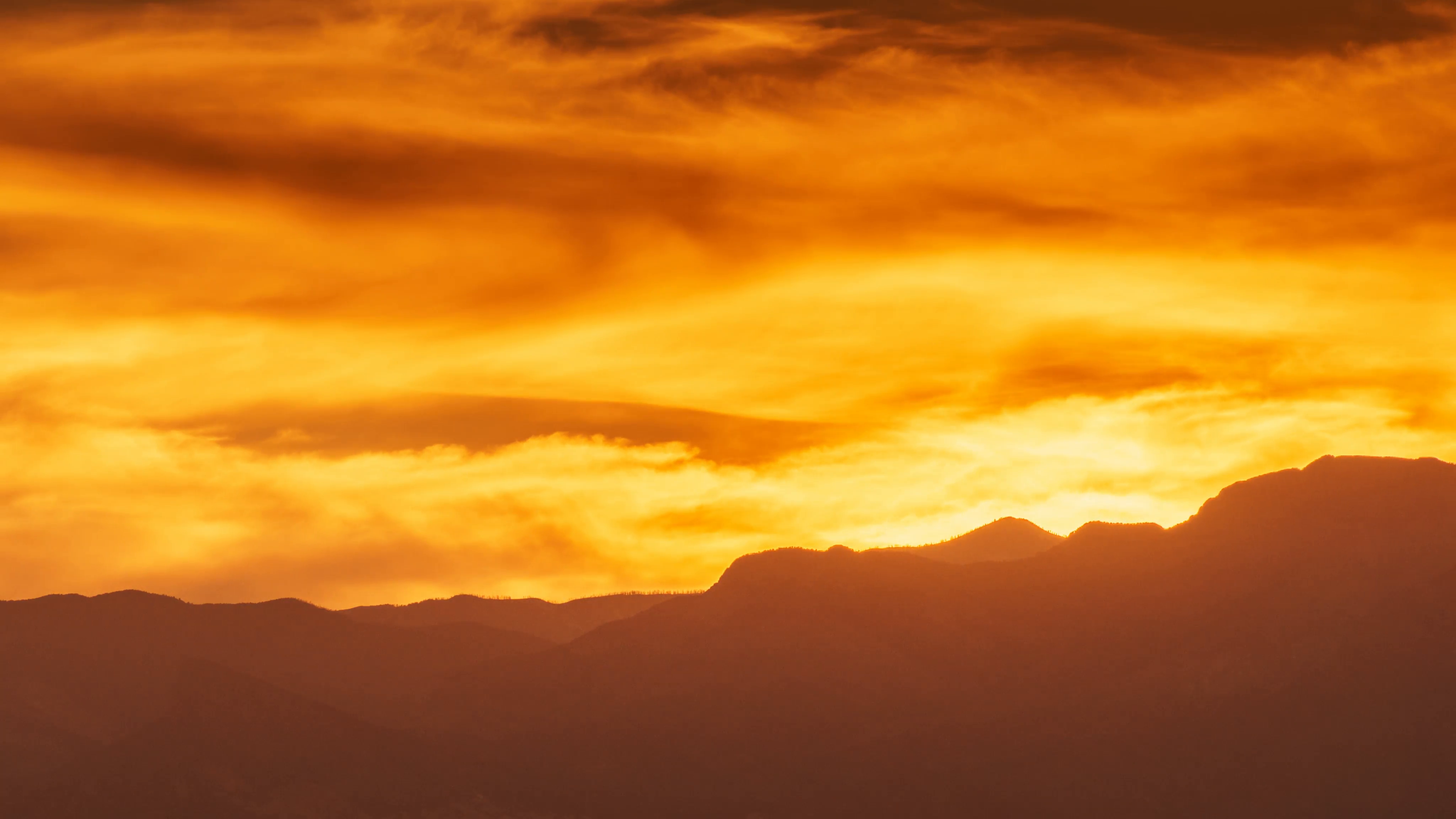 Colorful orange and yellow fiery sunset over mountain range. 4K UHD ...