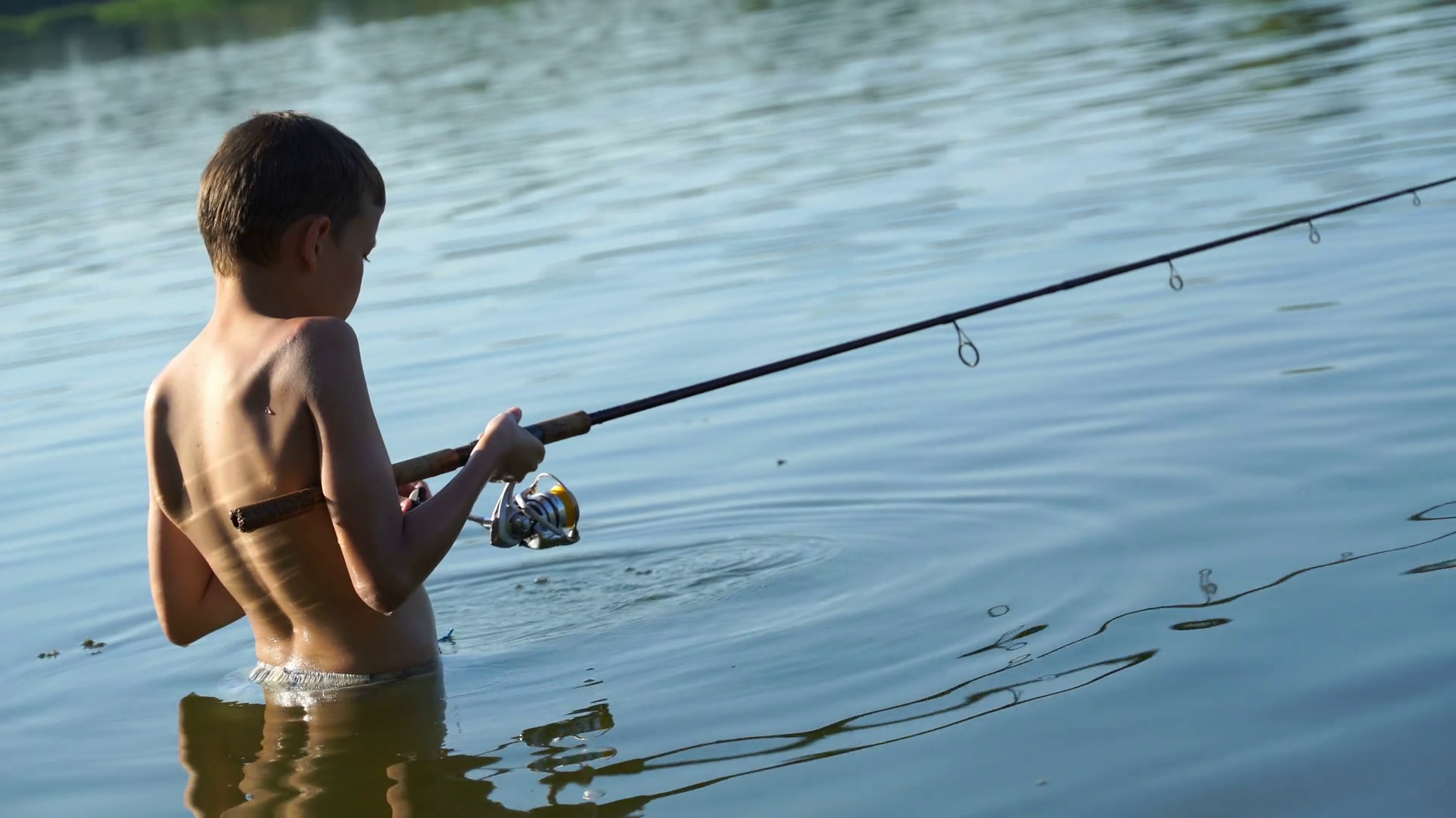 on the lake young fisherman fishing on a spinning. 4K Stock Video ...