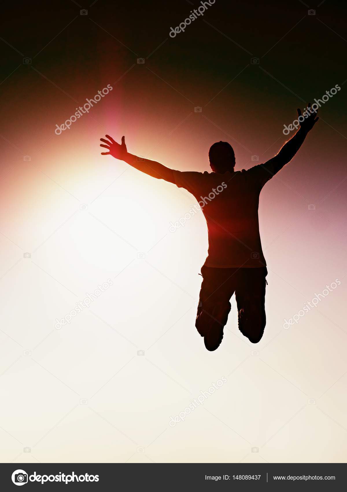 Jumping man. Young crazy man is jumping on red sky background ...