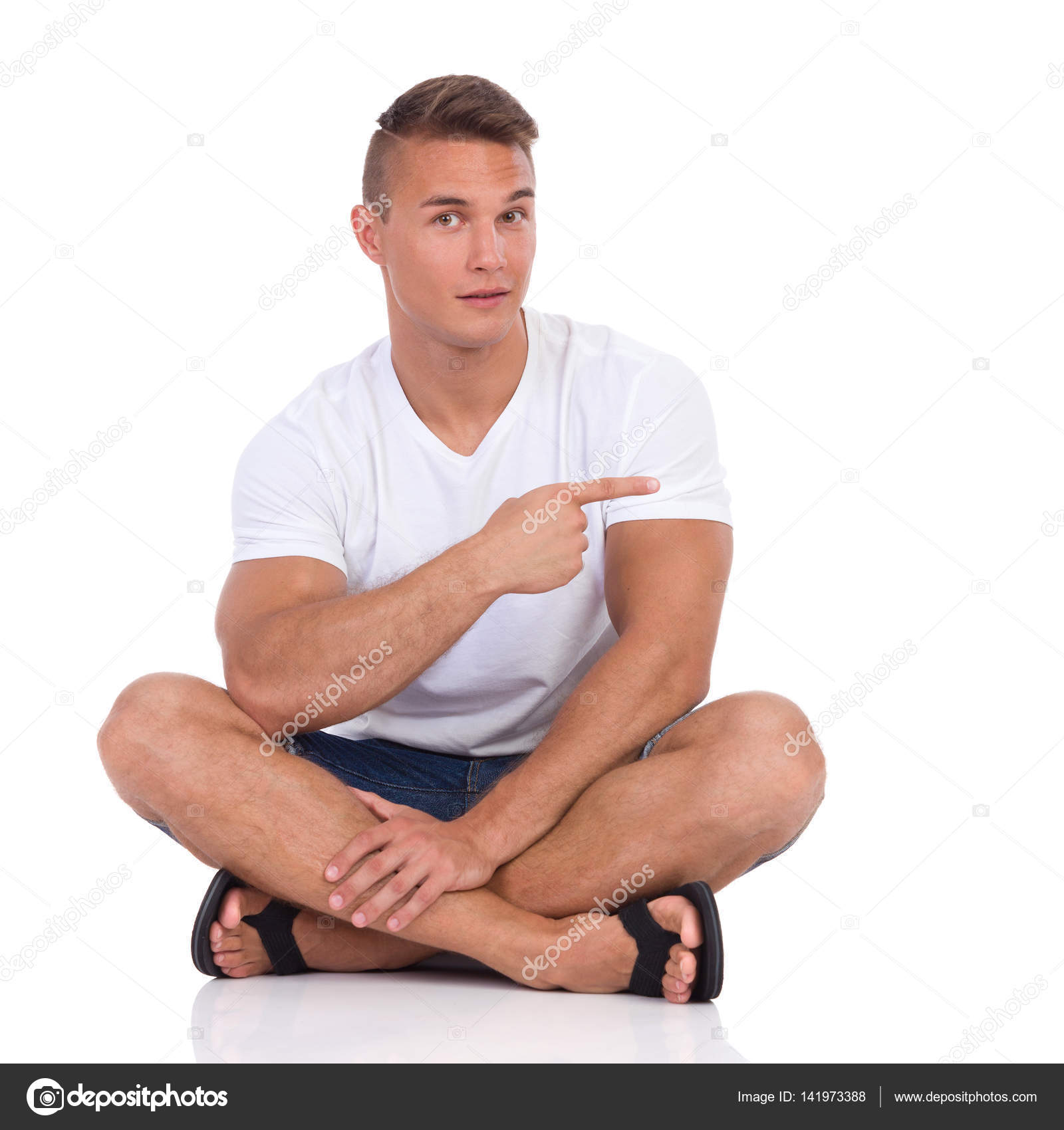 Young Man Sitting Legs Crossed And Pointing — Stock Photo ...