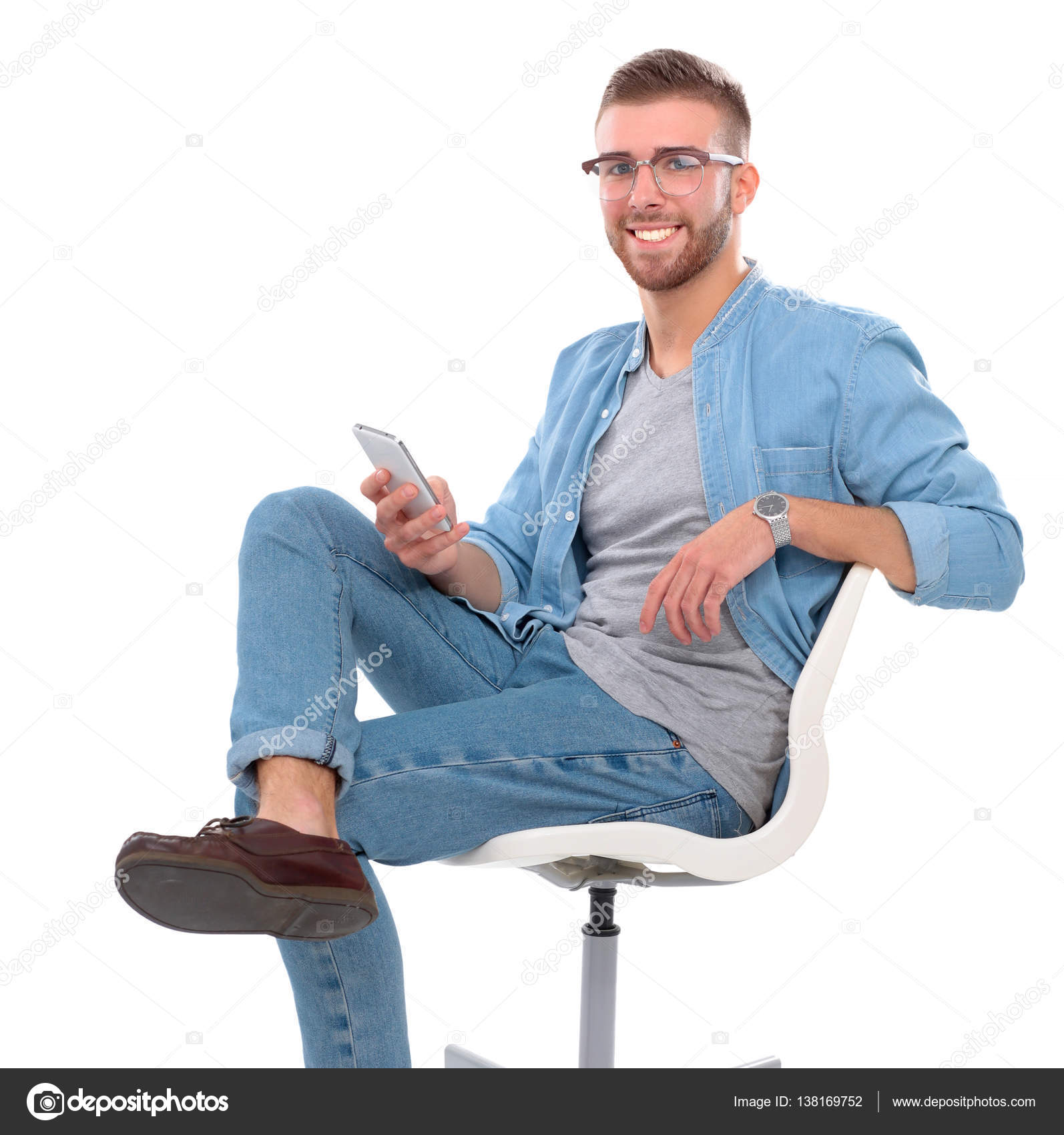 Young man sitting on chair and using mobile phone — Stock Photo ...