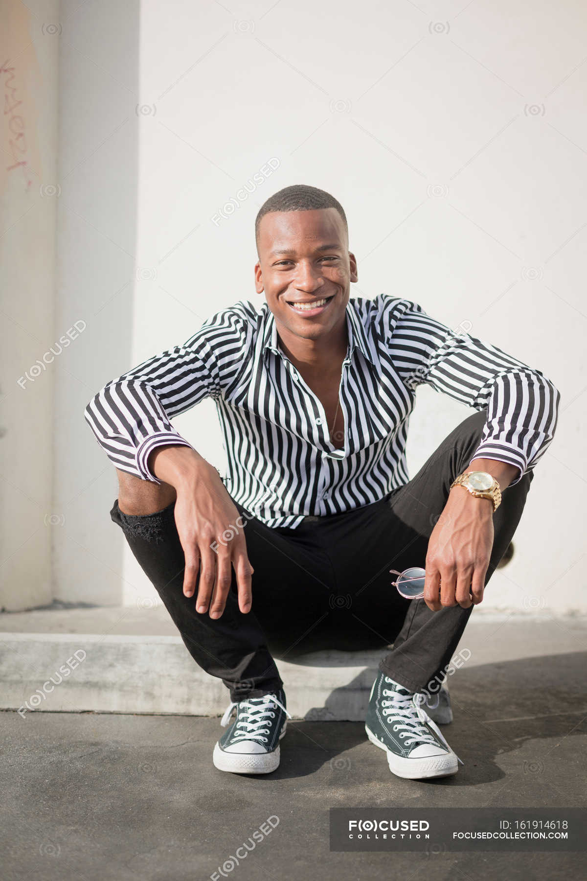 Young man sitting on kerb — Stock Photo | #161914618
