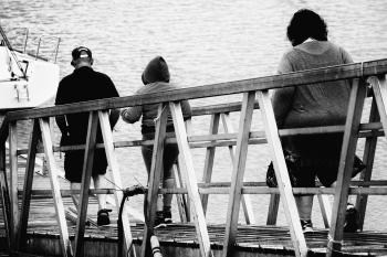 3 Person Walking on Bridge Black and White Photo