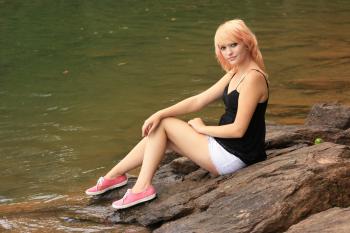 A beautiful young woman posing on a rock