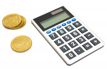 A calculator and a stack of gold coins