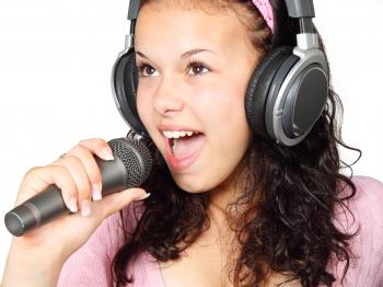 A Girl Holding a Microphone With a Headphone